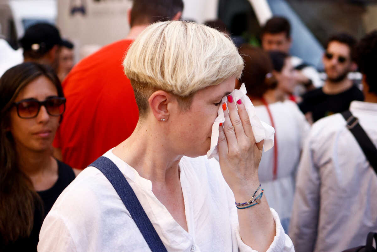A woman wipes sweat off, as she queues to enter the Pantheon, during a heatwave across Italy, in Rome, Italy July 19, 2023. REUTERS