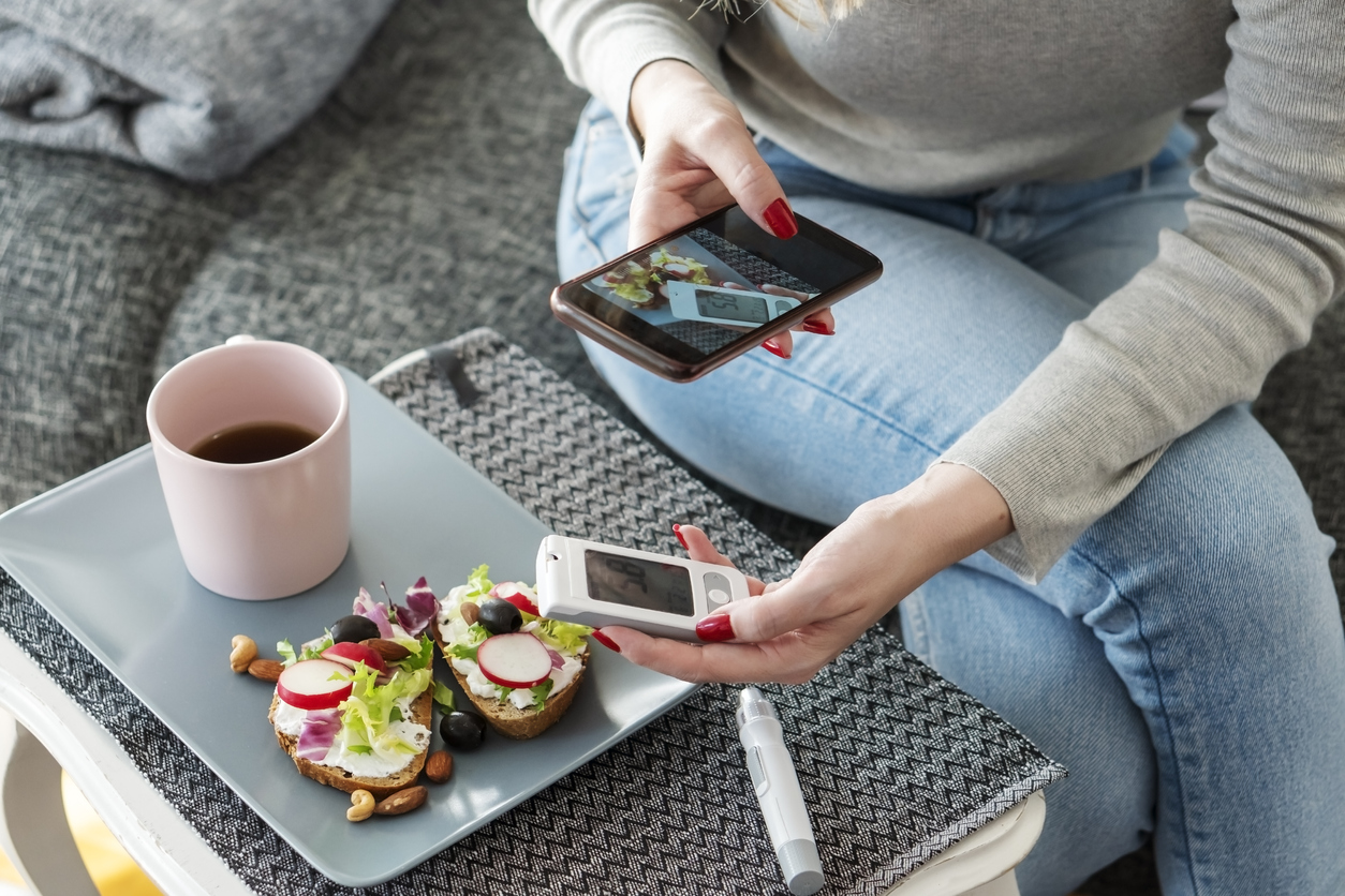 Mid adult diabetic woman having breakfast at home during pandemic crisis.