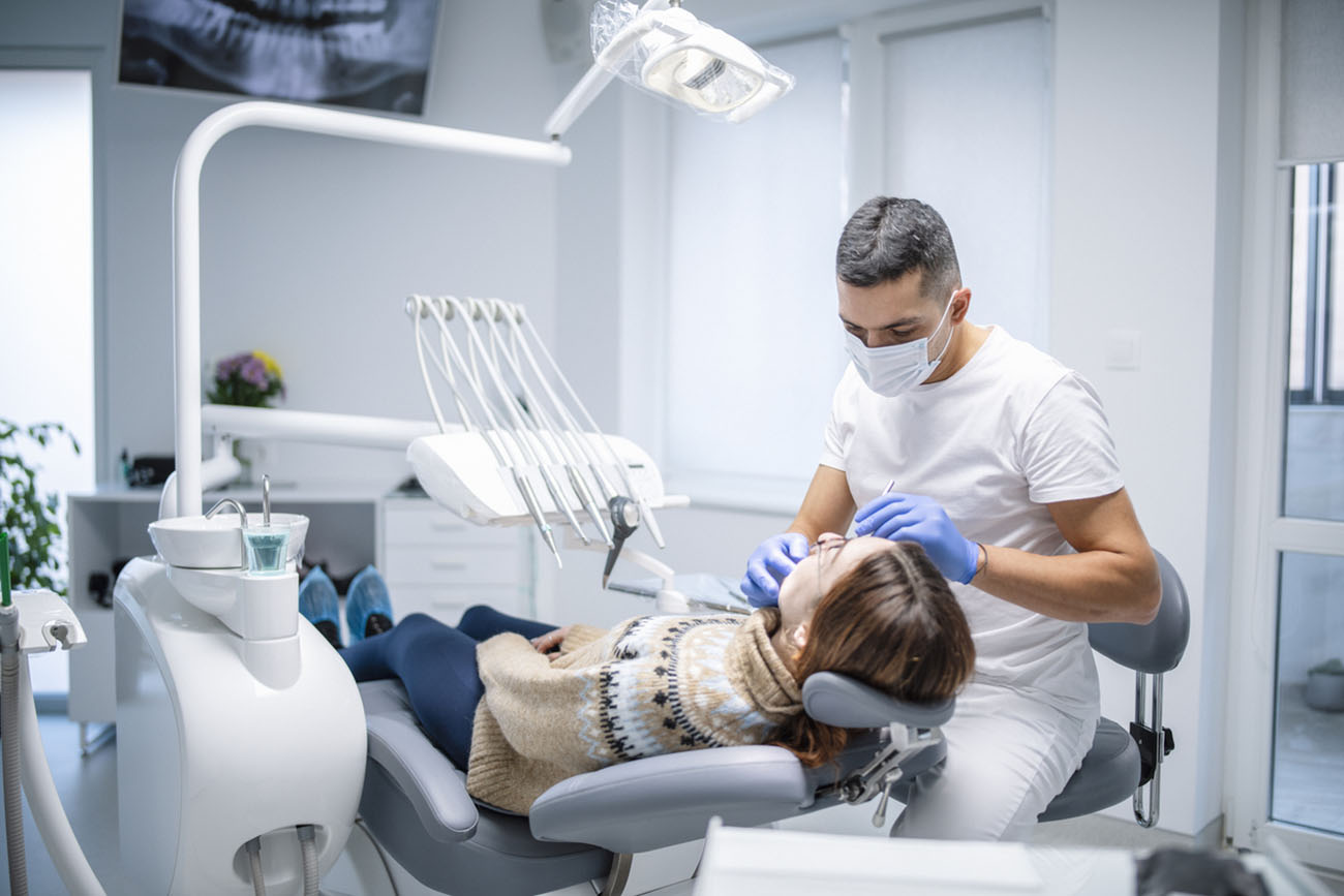 Dentist exzmining female patient at medical clinic.