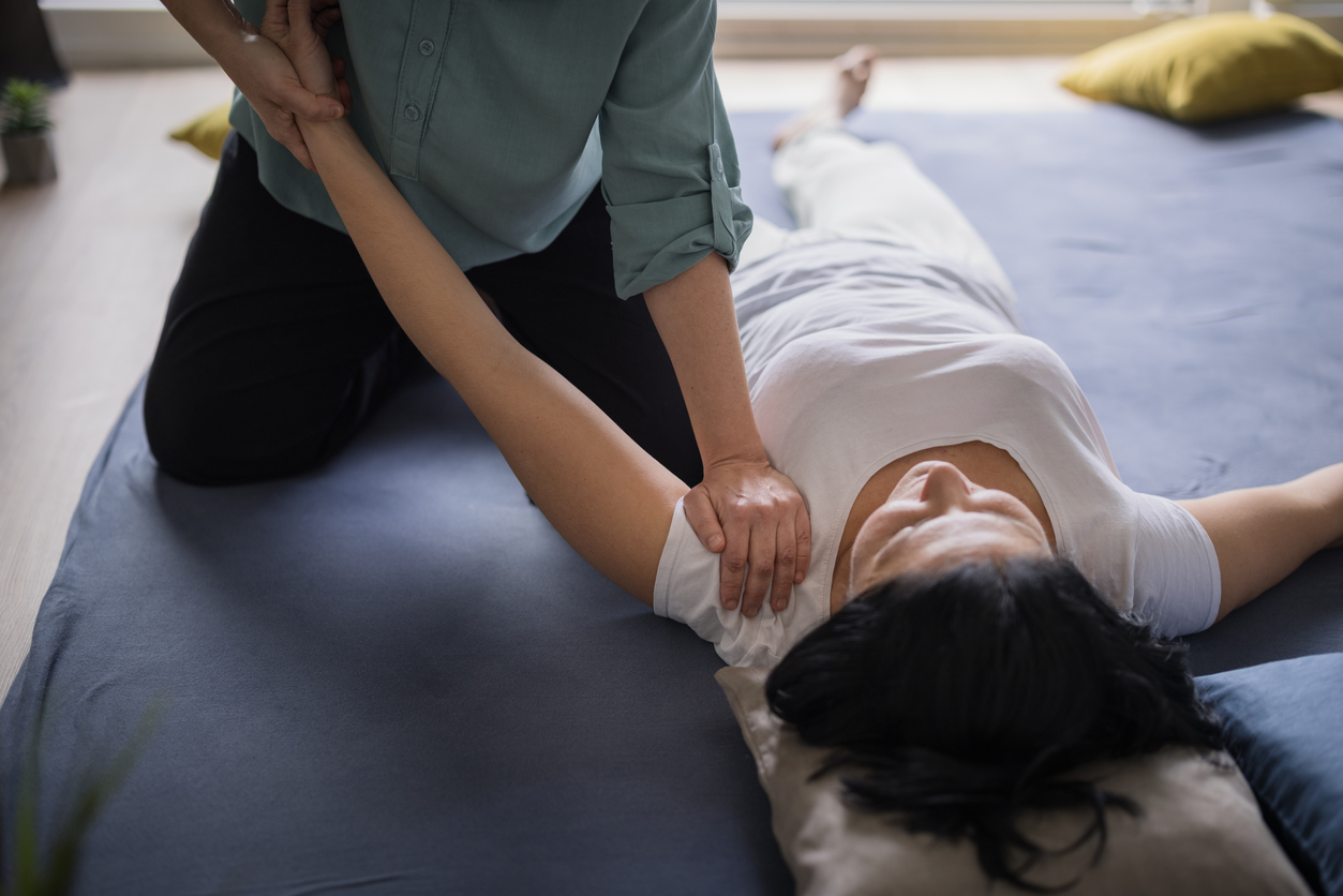 Young woman having arm and shoulder issues and seeking results in an alternative medicine
