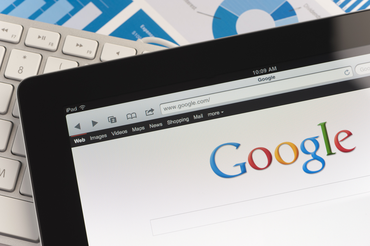 Sydney, Australia - September 6, 2011: Close up of an Apple Ipad and on a desk showing the Google search engine home screen. There is also a keyboard and some documents on the desk, the documents show charts and graphs. This scene depicts ipad in a working environment.