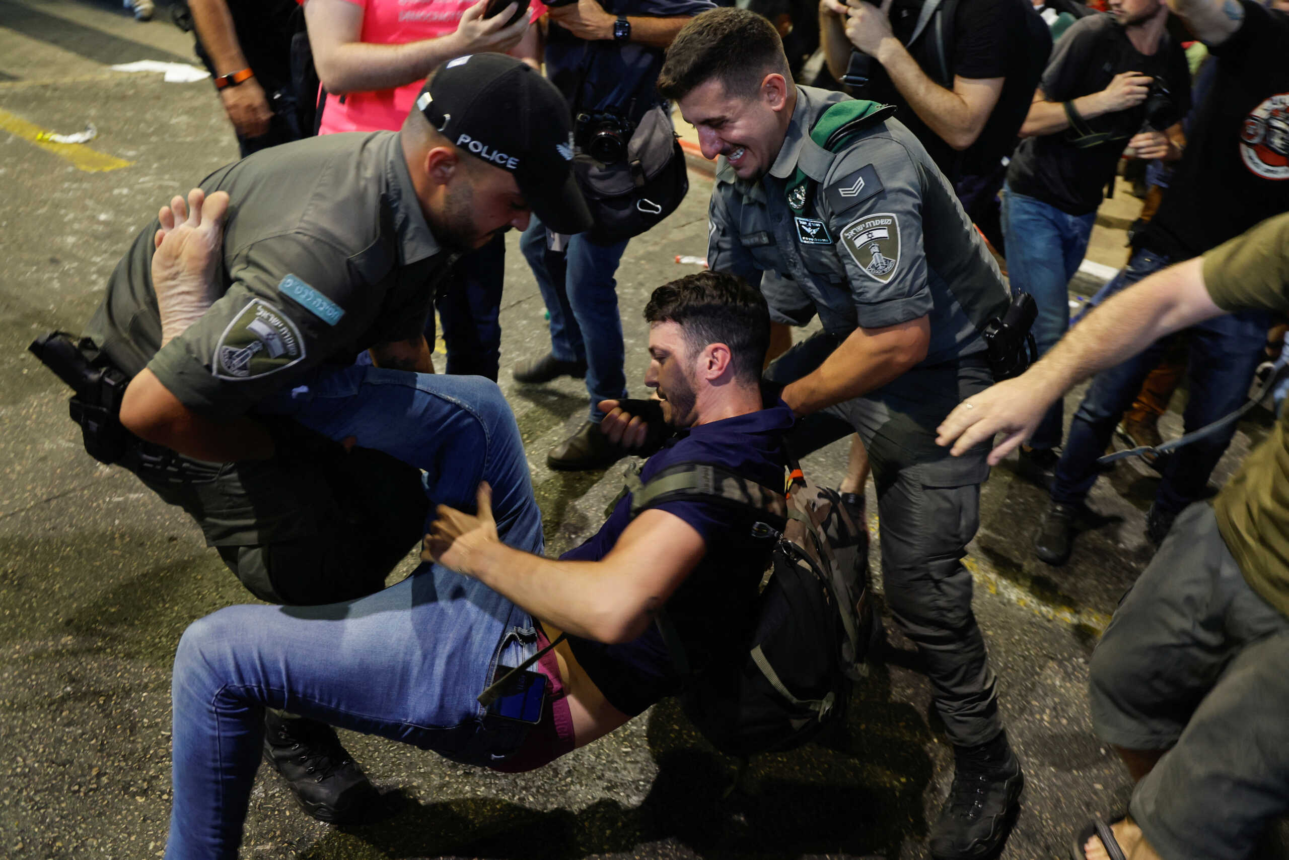 A protester is detained by police officers during a demonstration at Ben Gurion International Airport as a response to Israeli Prime Minister Benjamin Netanyahu and his nationalist coalition government's judicial overhaul, in Lod, Israel July 3, 2023. REUTERS