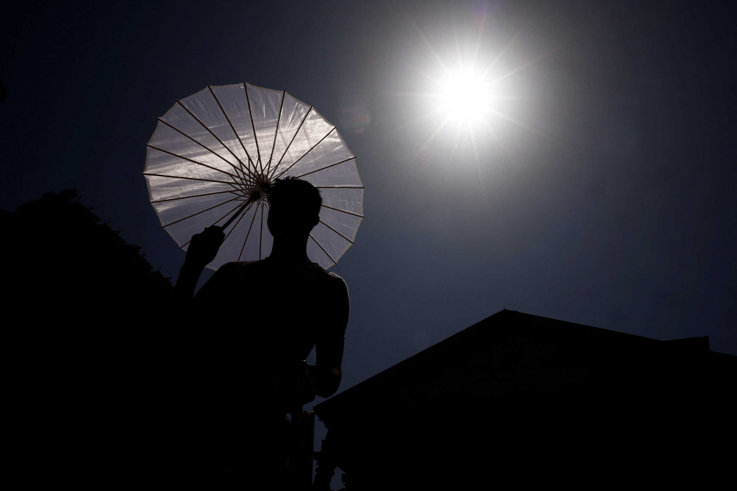 A man sells umbrellas during a heatwave across Italy, in Rome, Italy July 19, 2023. REUTERS