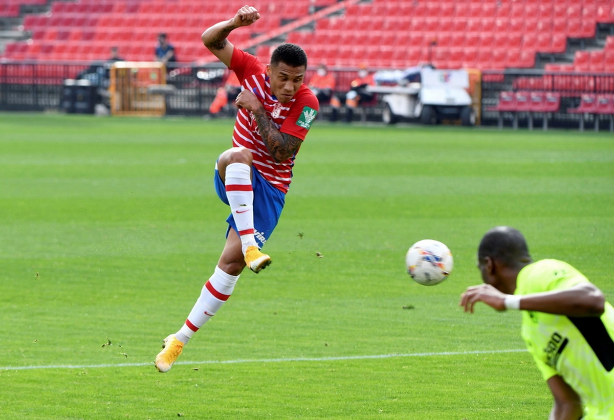 epa09009503 Granada's Brazilian midfielder defender Robert Kenedy Nunes do Nascimento 'Kenedy' (L)  in action during the Spanish LaLiga soccer match between Granada CF and Atletico Madrid at Nuevo de los Carmenes stadium in Granada, Andalusia region, southern Spain, 13 February 2021.  EPA