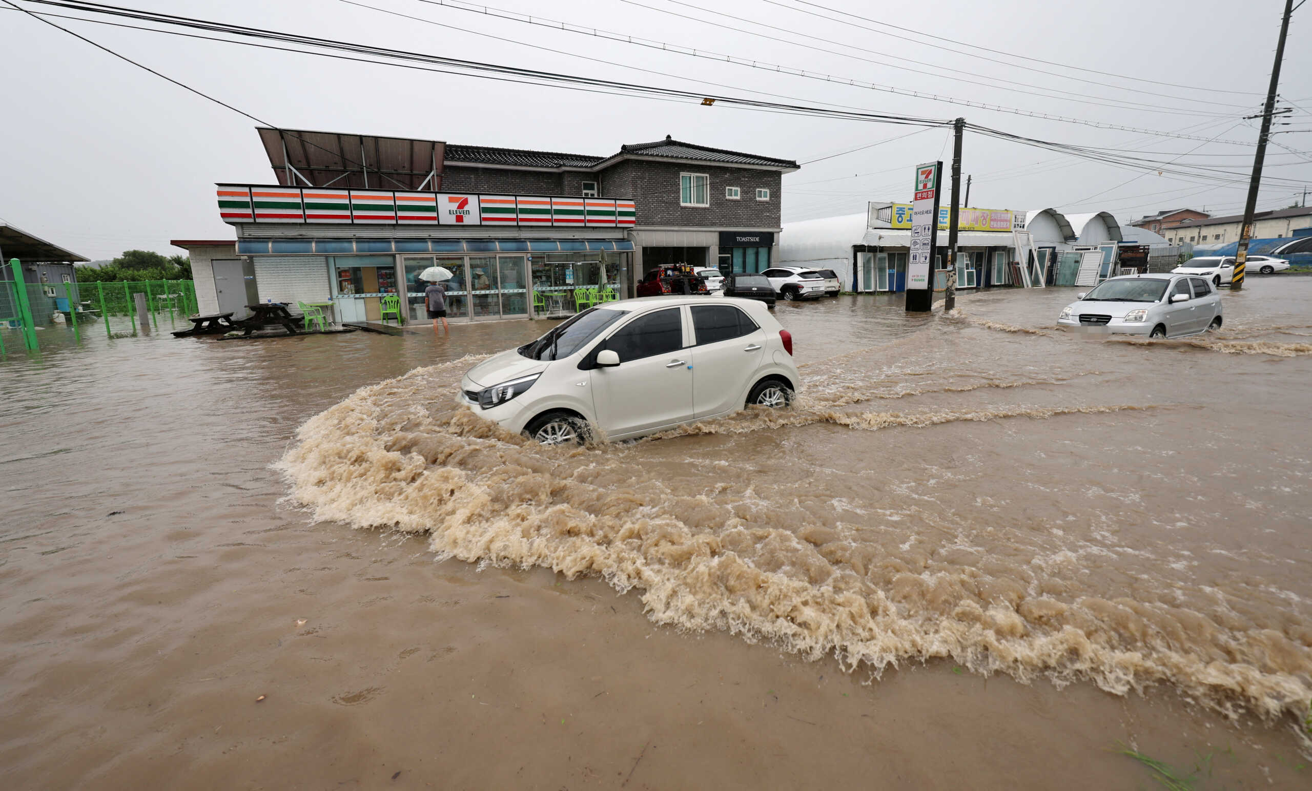 A vehicle makes its way through a flooded area caused by heavy rain in Cheongju, South Korea, July 15, 2023.   Yonhap
