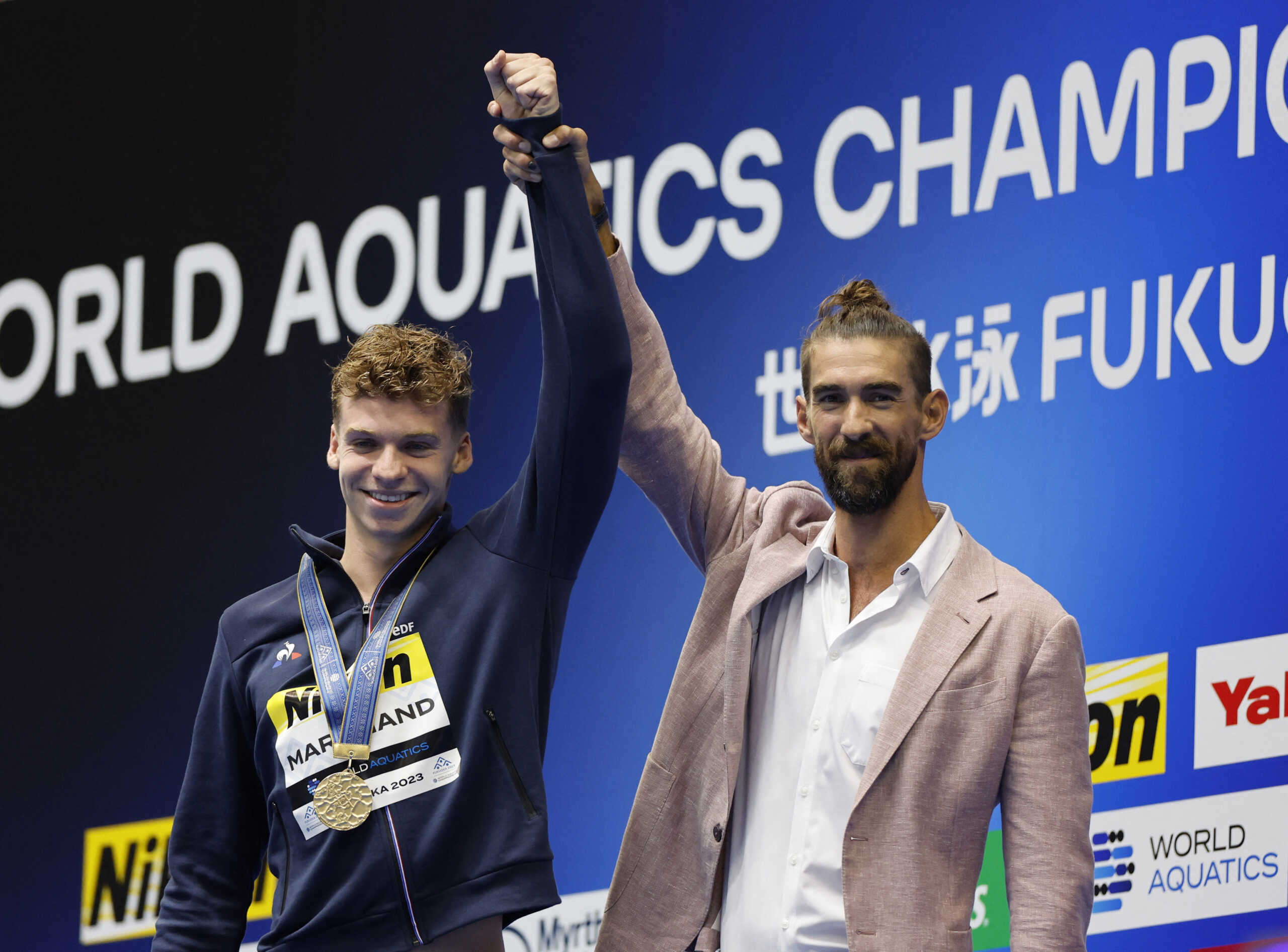 Fukuoka 2023 World Aquatics Championships - Swimming - Marine Messe Fukuoka Hall A, Fukuoka, Japan - July 23, 2023  France's Leon Marchand celebrates with former U.S. swimmer Michael Phelps after winning the men's 400m medley final REUTERS