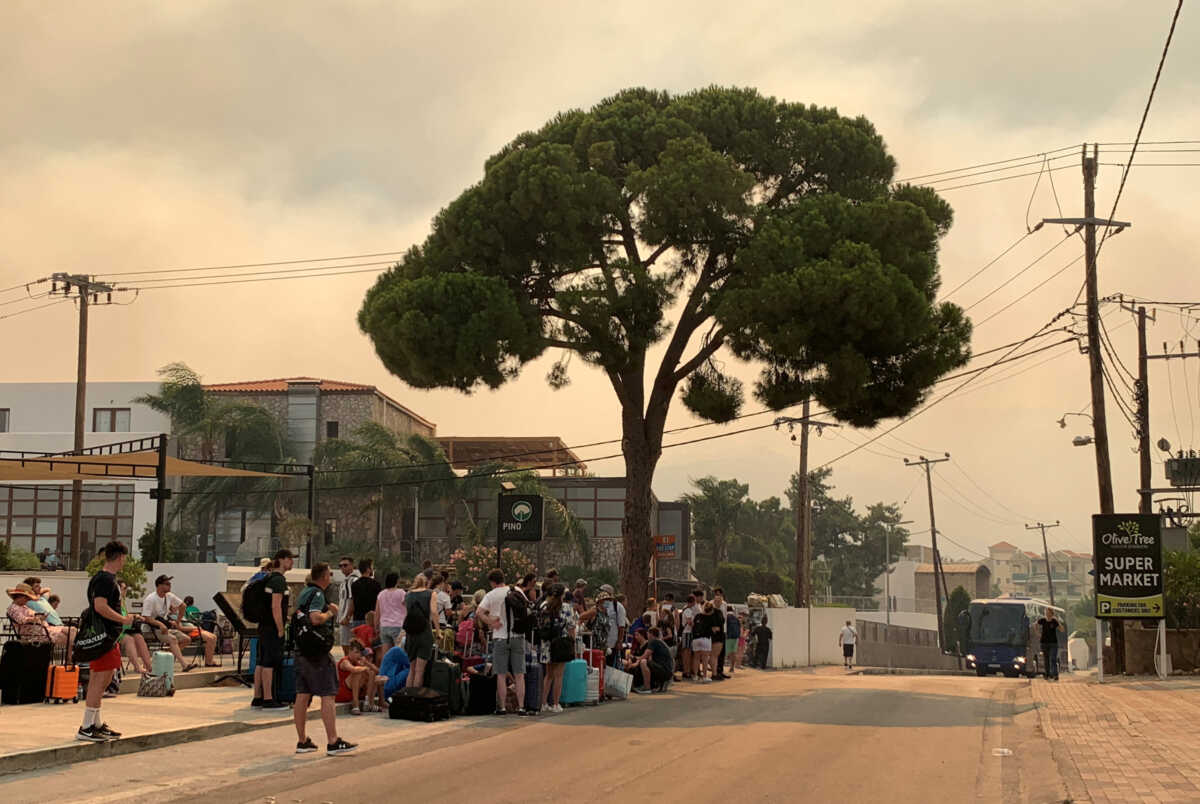 Tourists are being evacuated as wildfire burns near Lindos, on the island of Rhodes, Greece, July 22, 2023. REUTERS