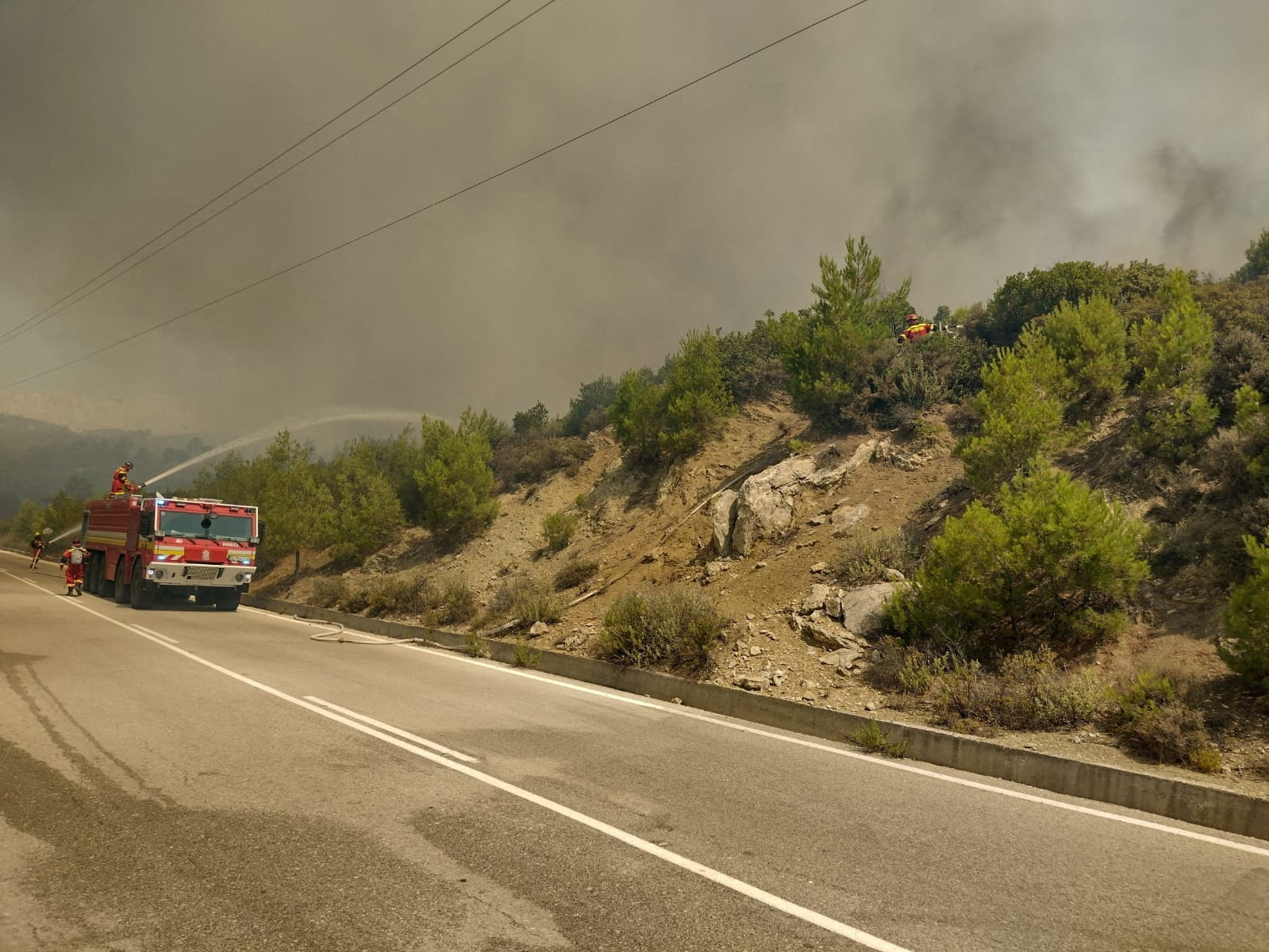 Firefighters try to extinguish a wildfire burning near Laerma, Rhodes Island, Greece, July 22, 2023. HAZZ Slovak Fire and Rescue Services