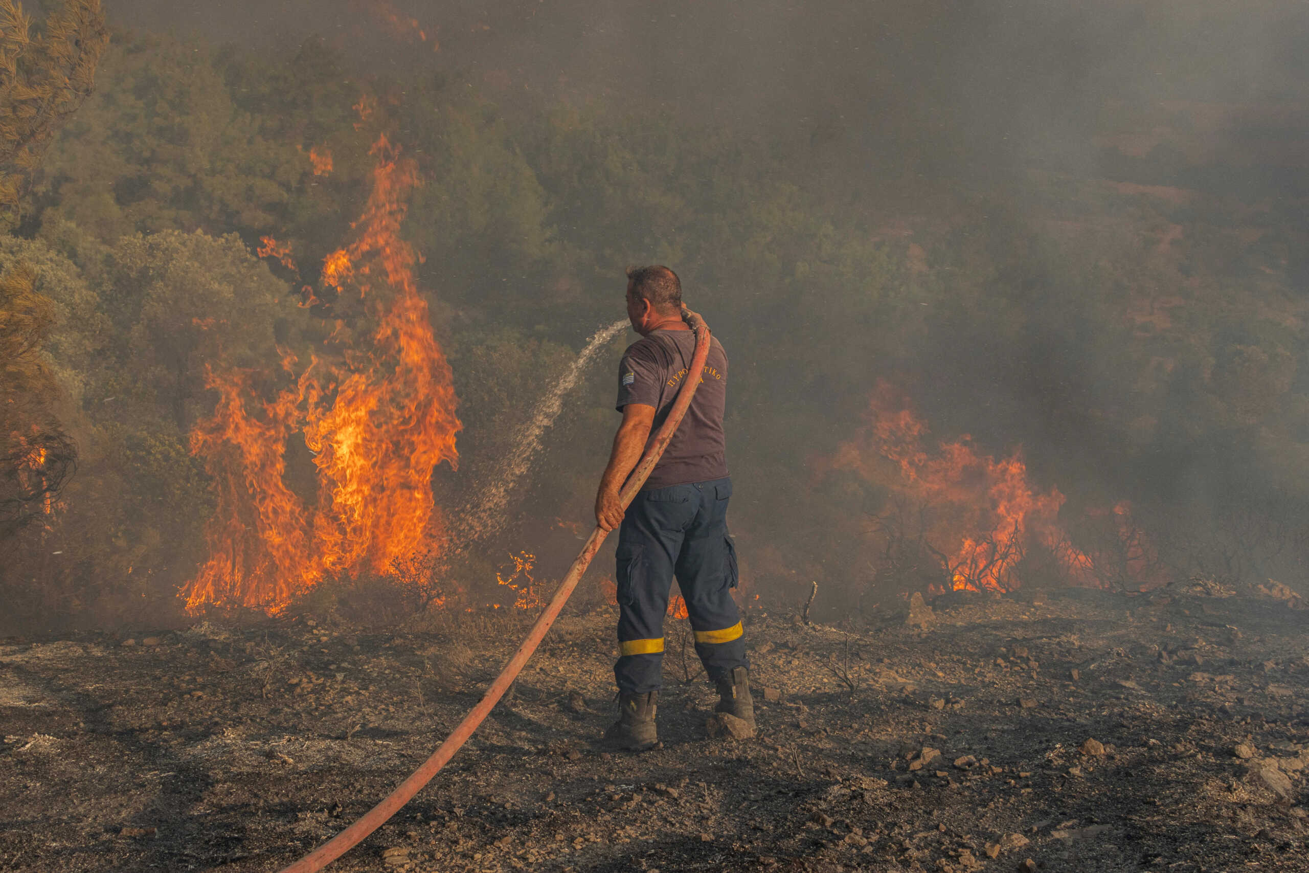 Firefighter Nektarios Kefalas tries to extinguish a wildfire burning near the village of Asklipieio, on the island of Rhodes, Greece, July 24, 2023. REUTERS