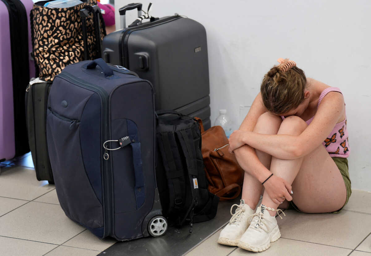 A tourist from Wales waits for departing planes at the airport, after being evacuated following a wildfire on the island of Rhodes, Greece, July 23, 2023. REUTERS