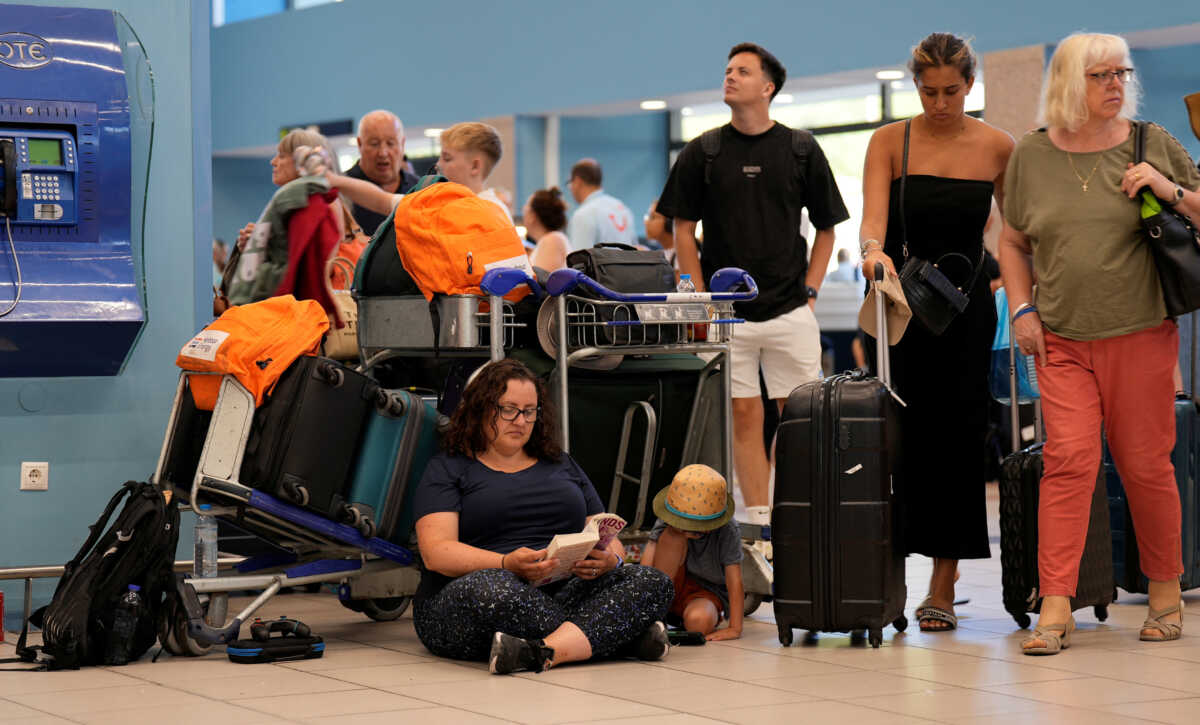 Tourists wait for departing planes at the airport, after being evacuated following a wildfire on the island of Rhodes, Greece, July 23, 2023. REUTERS