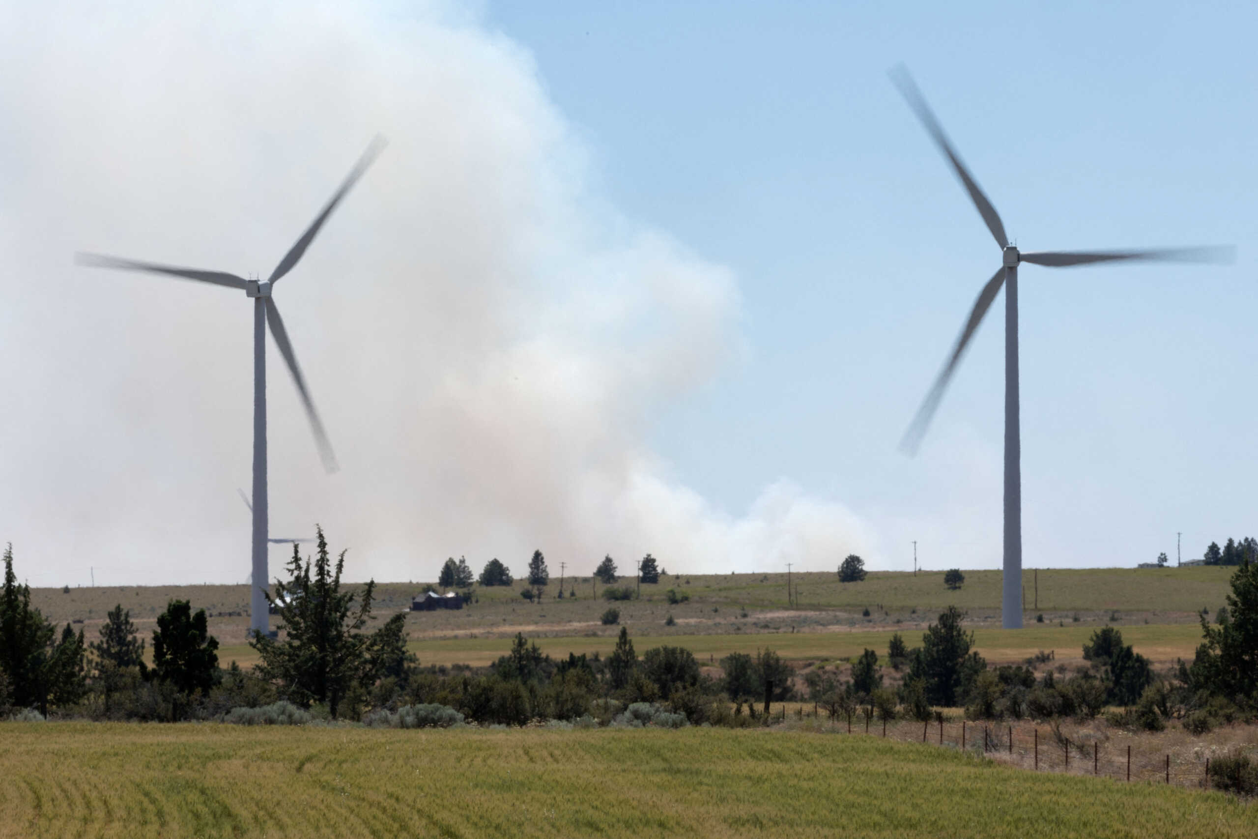 Smoke from the Newell Road Fire near Goldendale, Washington is seen amid wind turbines in Bickleton, Washington, U.S., July 22, 2023. REUTERS