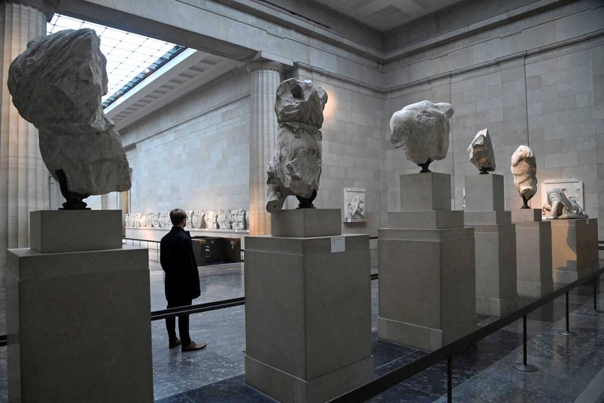 FILE PHOTO: An employee poses as he views examples of the Parthenon sculptures, sometimes referred to in the UK as the Elgin Marbles, on display at the British Museum in London, Britain, January 25, 2023. REUTERS