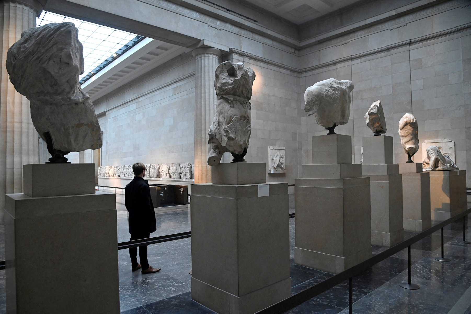 FILE PHOTO: An employee poses as he views examples of the Parthenon sculptures, sometimes referred to in the UK as the Elgin Marbles, on display at the British Museum in London, Britain, January 25, 2023. REUTERS