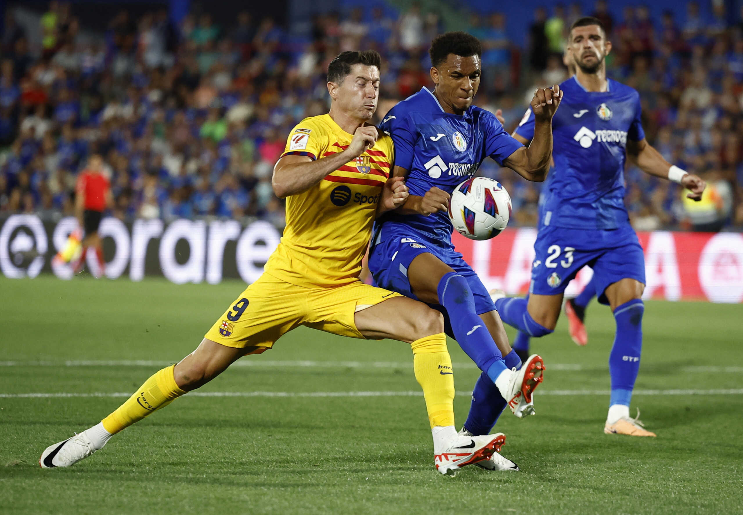 Soccer Football - Spain - LaLiga - Getafe v FC Barcelona - Coliseum Alfonso Perez, Getafe, Spain - August 13, 2023  FC Barcelona's Robert Lewandowski in action with Getafe's Gaston Alvarez REUTERS