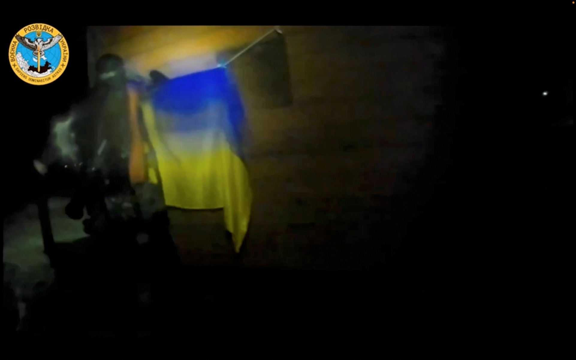 A Ukrainian soldier hangs a Ukrainian flag during a 'special operation' by Ukrainian forces at a location given as near Olenivka and Mayak settlements, Crimea, in this screengrab obtained from a handout video released on August 24, 2023. Ukrainian Main Directorate of Intelligence