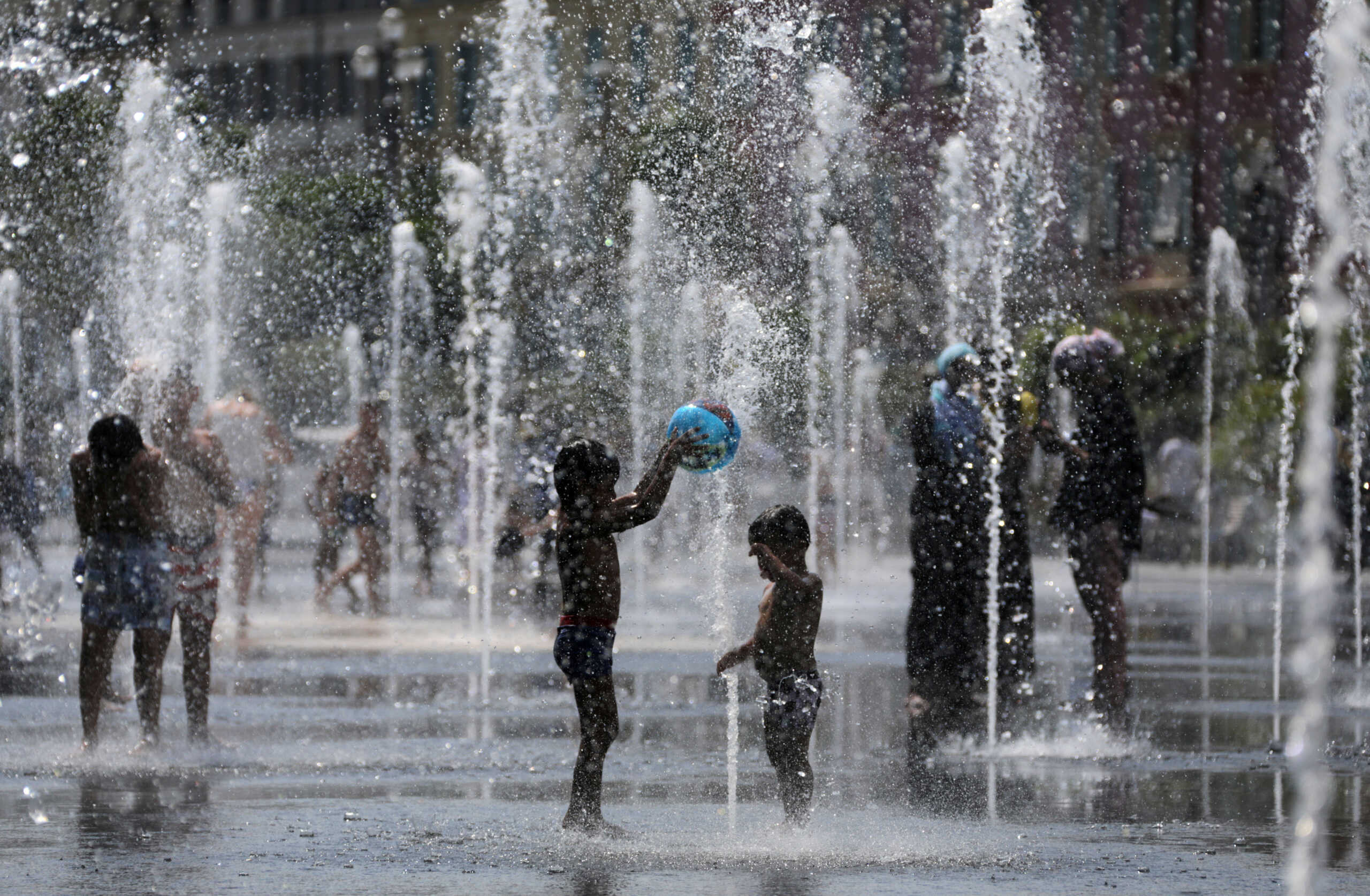 People cool off in water fountains in Nice as hot summer temperatures continue and authorities maintain a heat wave alert in France, August 1, 2018.  REUTERS
