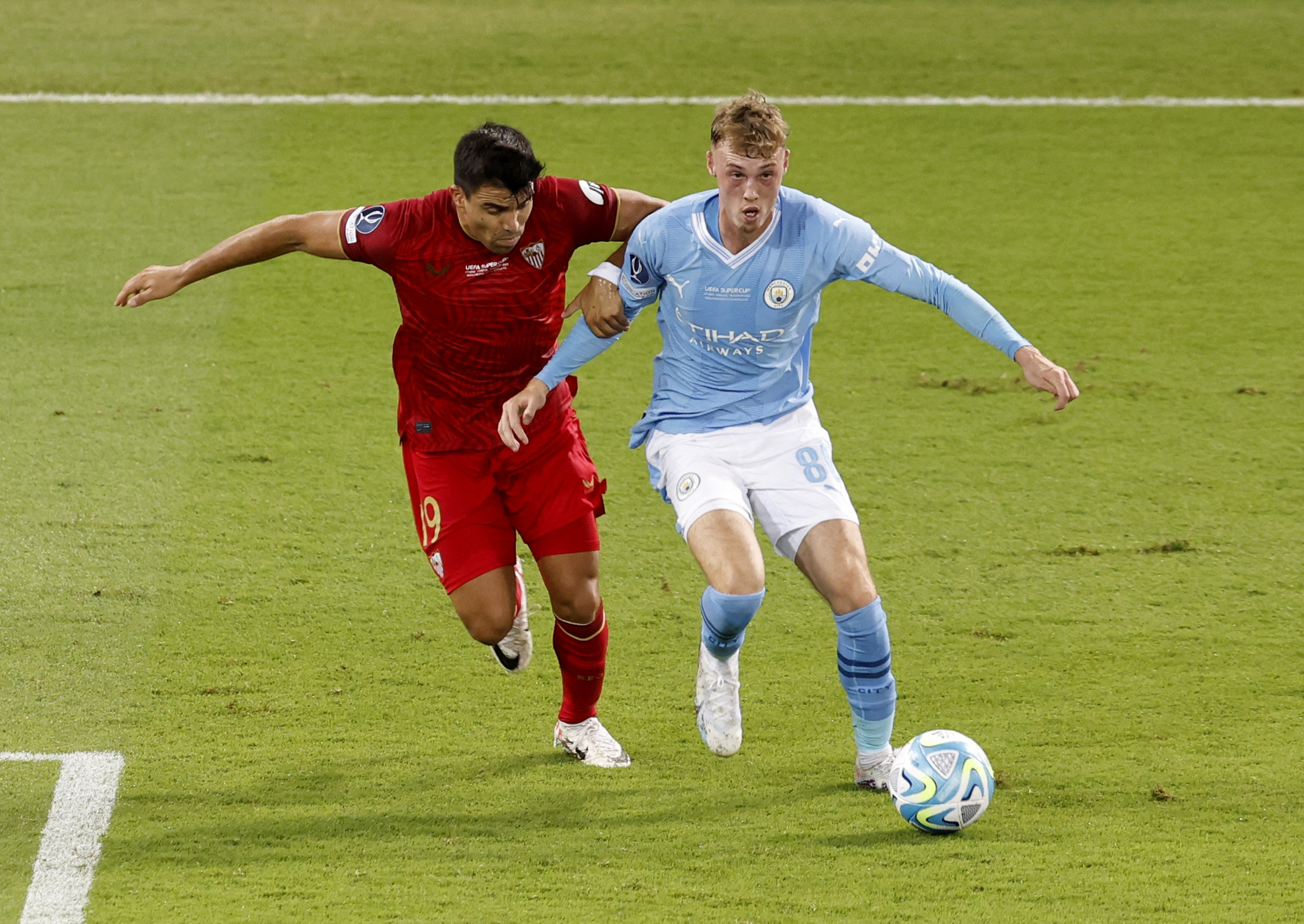 Soccer Football - UEFA Super Cup - Manchester City v Sevilla - Georgios Karaiskakis Stadium, Athens, Greece - August 16, 2023 Sevilla's Marcos Acuna in action with Manchester City's Cole Palmer REUTERS