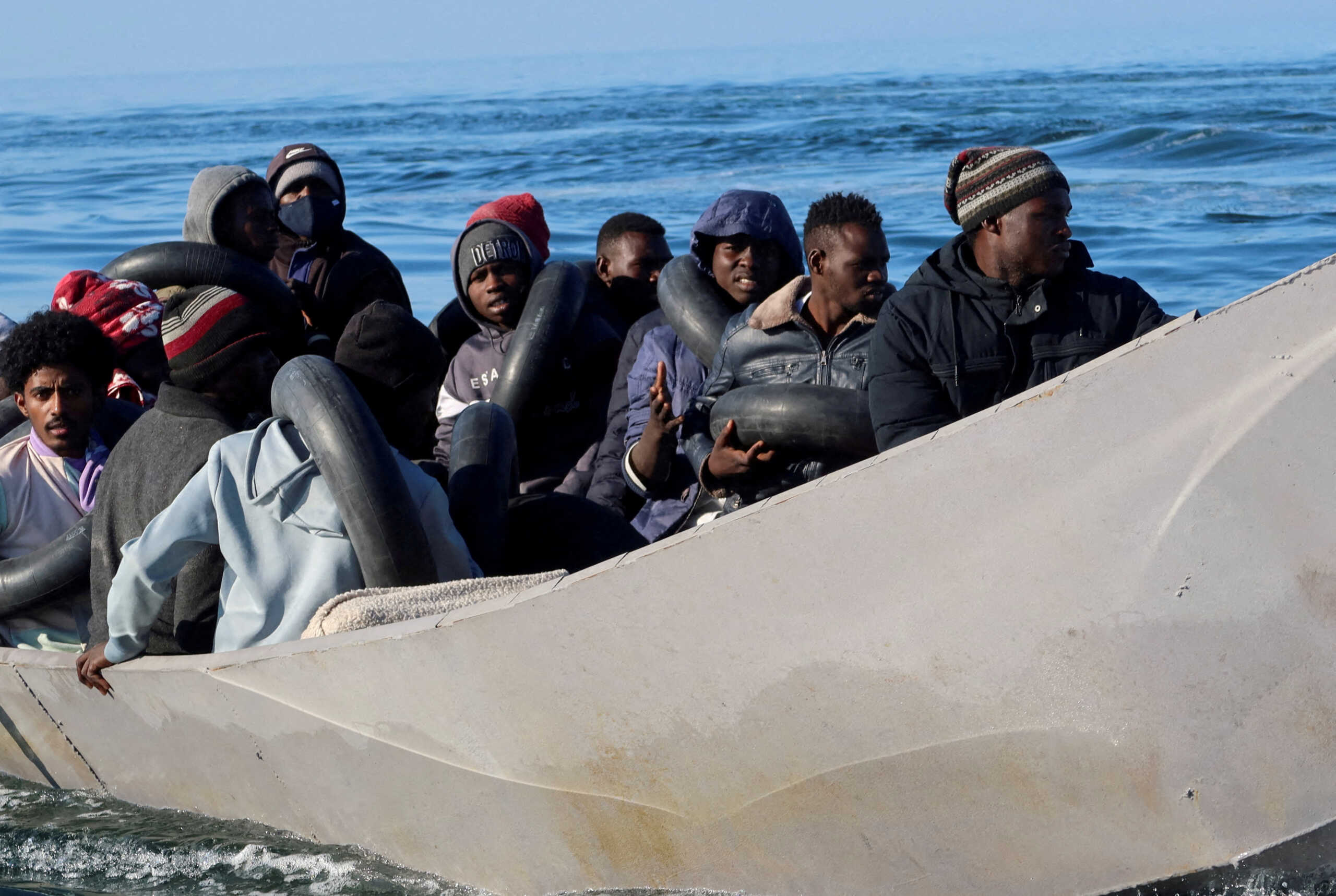 FILE PHOTO: Migrants are pictured on a metal boat as Tunisian coastguards try to stop them at sea during their attempt to cross to Italy, off Sfax, Tunisia April 27, 2023. REUTERS