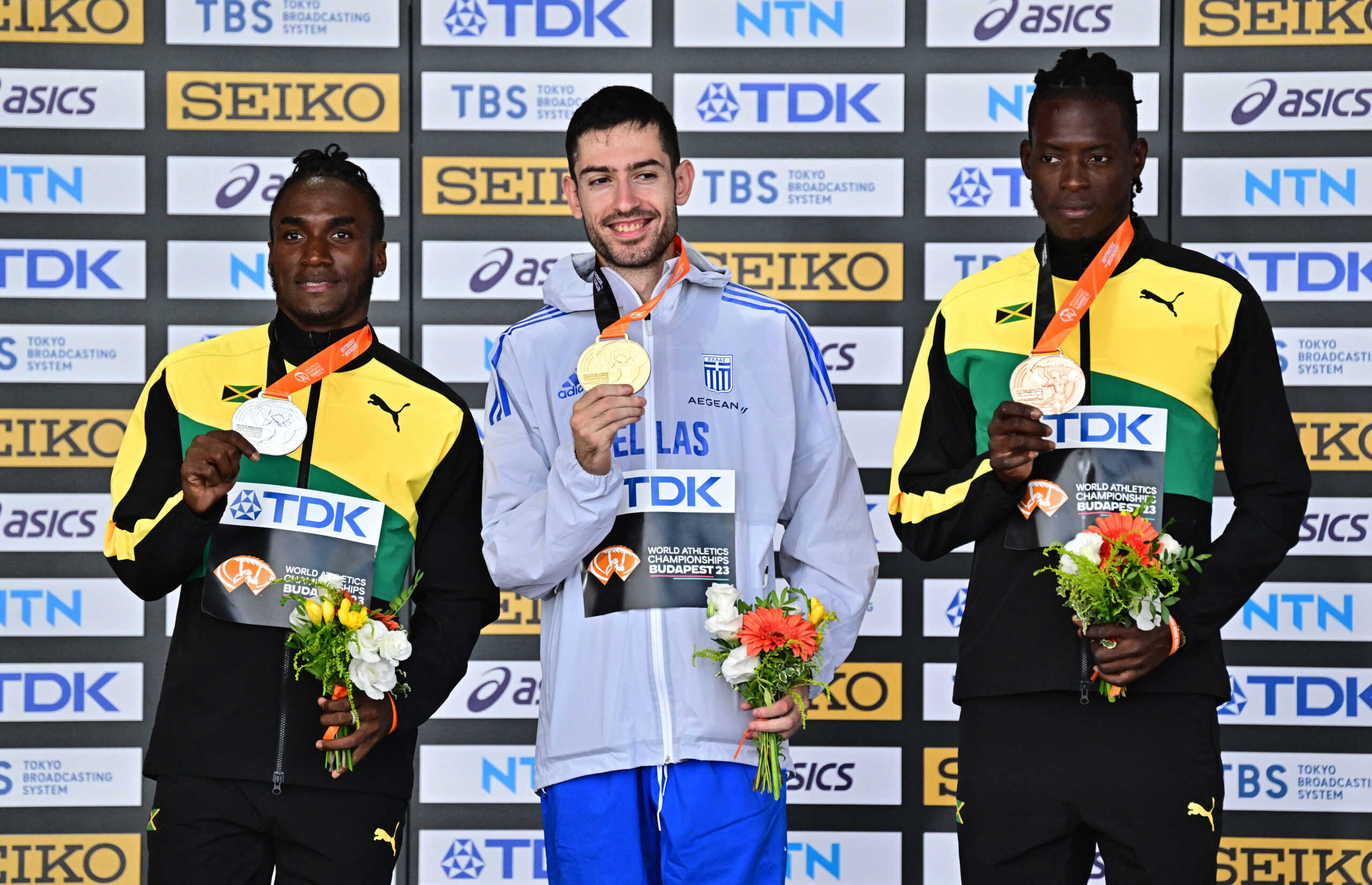 Athletics - World Athletics Championship - Men's Long Jump Final - Budapest, Hungary - August 25, 2023 Gold medallist Greece's Miltiadis Tentoglou celebrates on the podium during the medal ceremony alongside silver medallist Jamaica's Wayne Pinnock and bronze medallist Jamaica's Tajay Gayle REUTERS