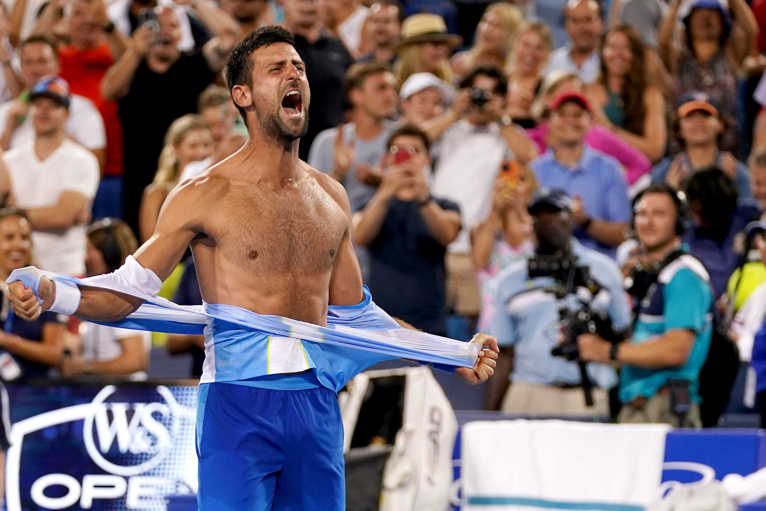 Aug 20, 2023; Mason, OH, USA; Novak Djokovic, of Serbia, rips his shirt in celebration after defeating Carlos Alcaraz, of Spain, at the conclusion of the menÕs singles final of the Western & Southern Open tennis tournament at Lindner Family Tennis Center. Mandatory Credit: Kareem Elgazzar