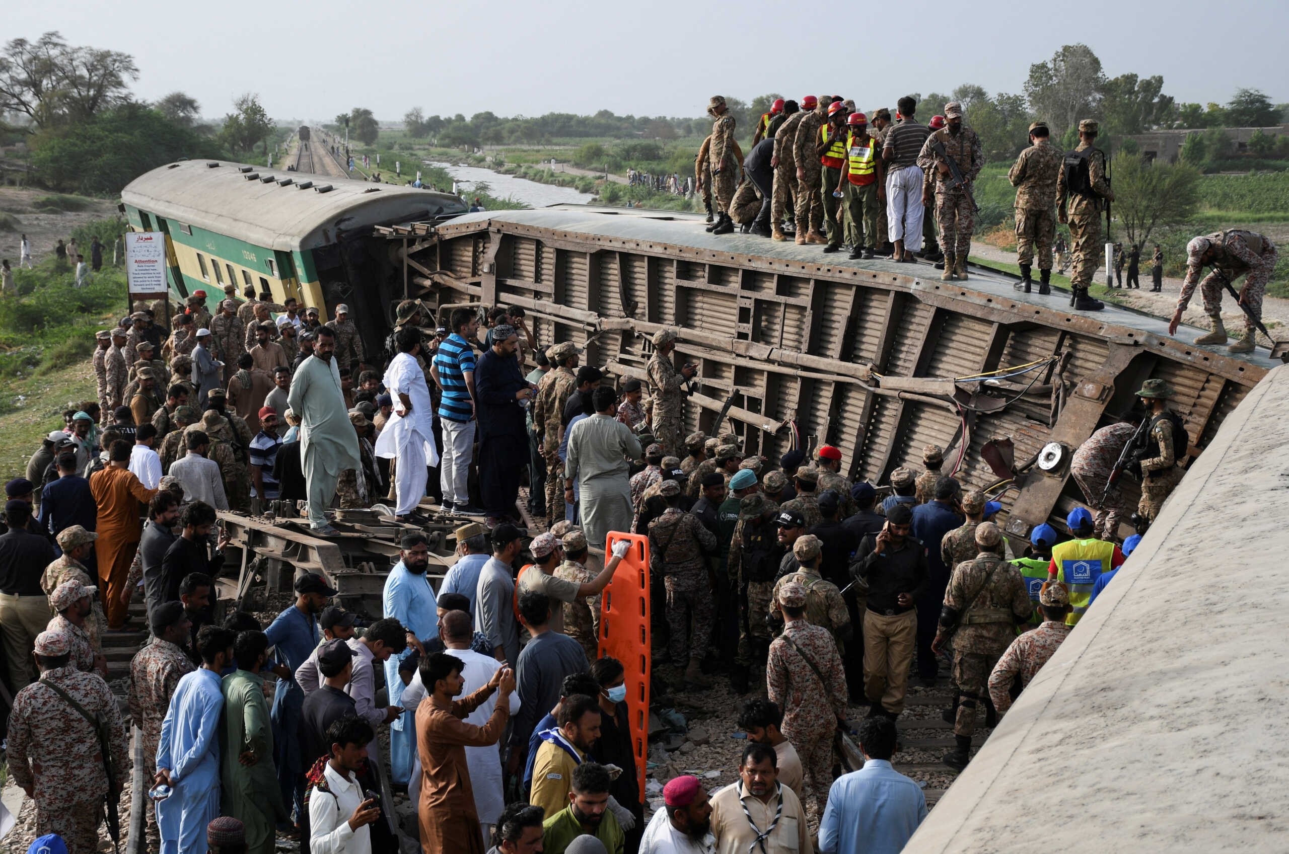 Pakistani army soldiers and rescue workers gather to search for survivors after a train derailed in Sarhari town in district Sanghar, Pakistan August 6, 2023. REUTERS