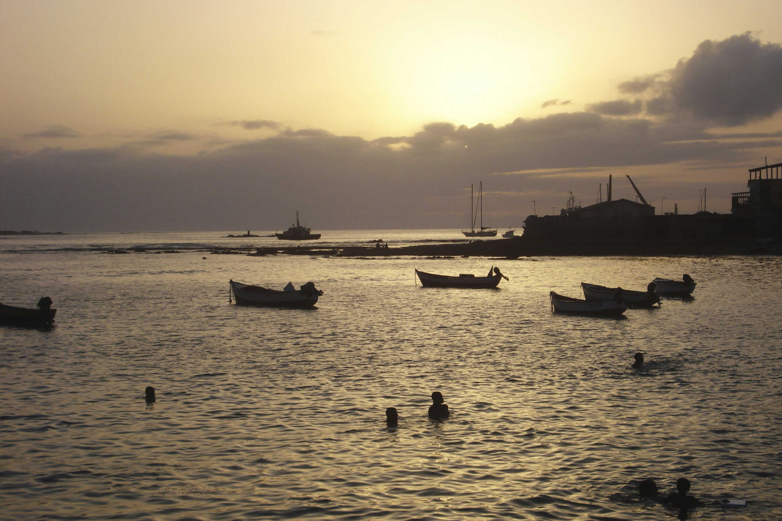 Children play in the water at sunset in the port of Sal Rei, the main town of Cape Verde's Boa Vista island, July 15, 2010. Unscathed by conflict or political instability, Cape Verde has quietly become a middle-income nation and looks set to be one of few in Africa to meet any of the Millennium Development Goals set for measuring progress in improving livelihoods. Yet it has even loftier ambitions. Picture taken July 15, 2010. REUTERS