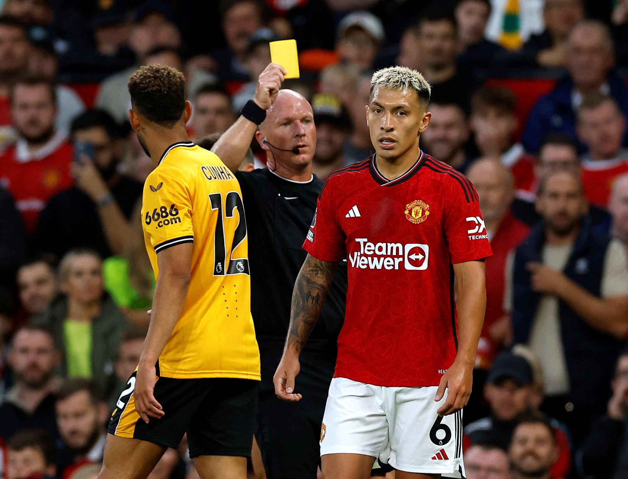 Soccer Football - Premier League - Manchester United v Wolverhampton Wanderers - Old Trafford, Manchester, Britain - August 14, 2023   Manchester United's Lisandro Martinez is shown a yellow card by referee Simon Hooper  Action Images via Reuters