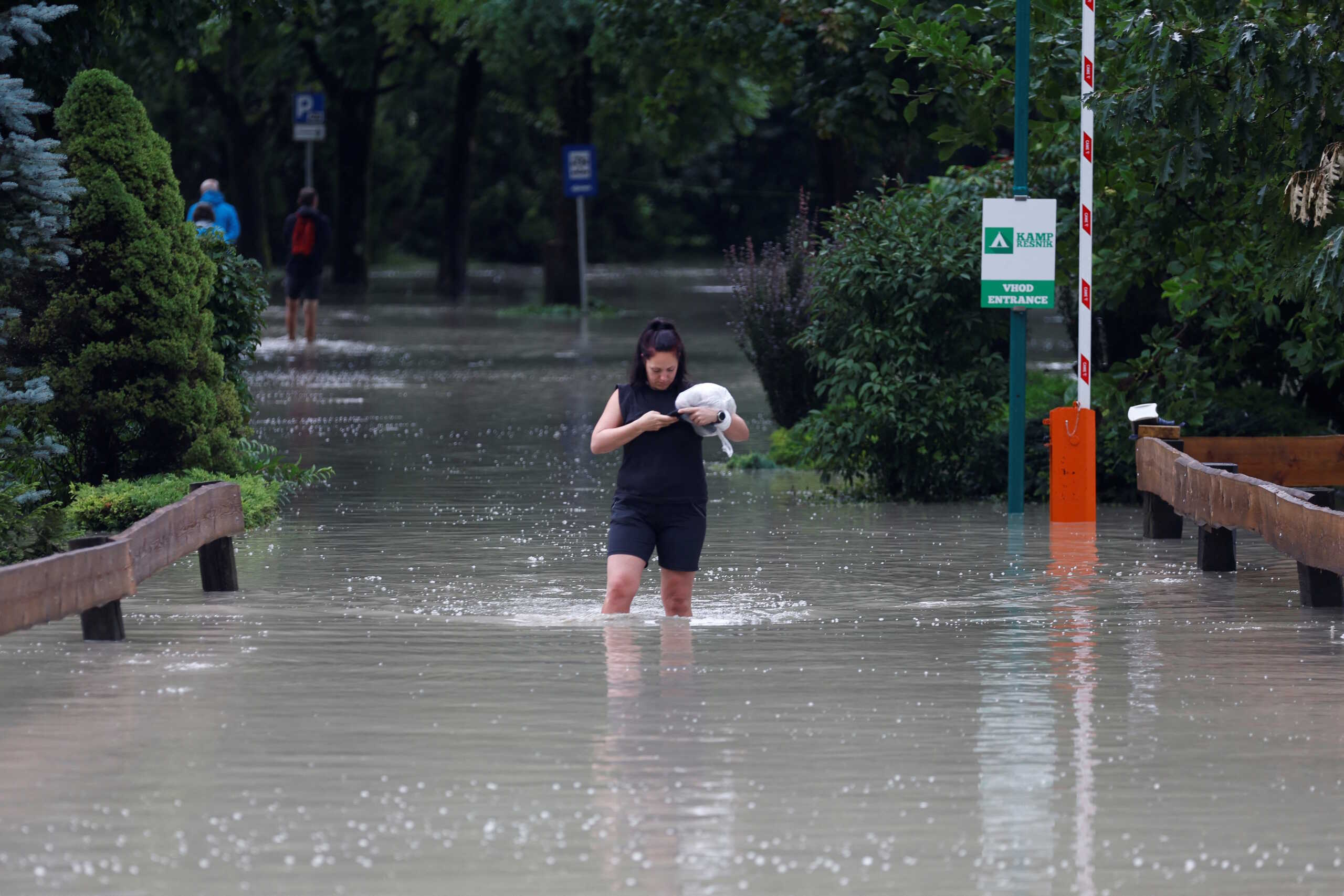 A woman wades in water during a flood in Kamnik, Slovenia August 4, 2023. REUTERS