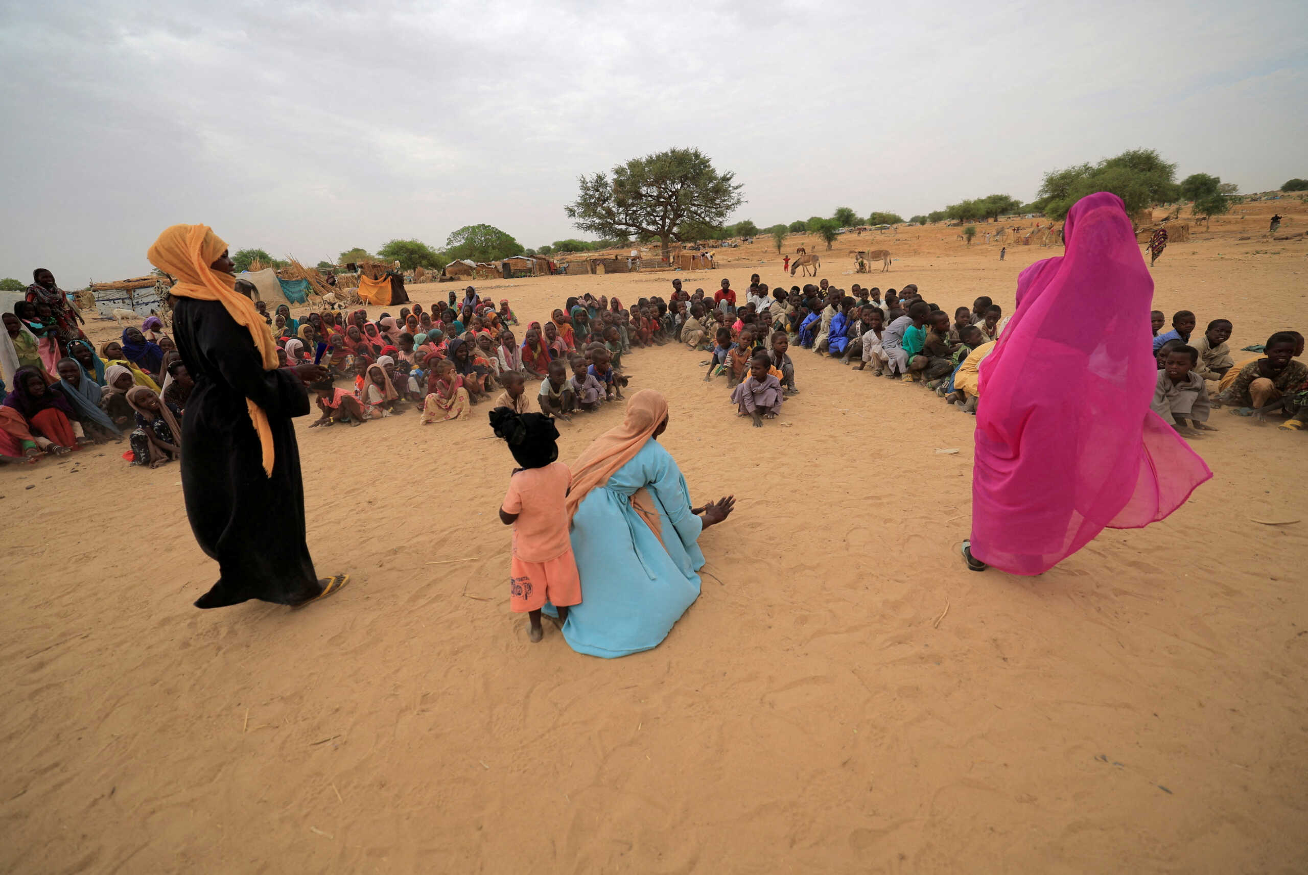 FILE PHOTO: Zahra Haroun, 19, Nawal Adama, 32, Zahra Mohamed, 20, Sudanese refugee teachers who have fled the violence in Sudan's Darfur region, give their first entertainment and sport training session for refugee children at makeshift shelters near the border between Sudan and Chad in Koufroun, Chad May 11, 2023. REUTERS