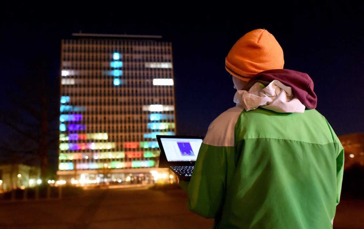 epa05235890 Student Merlin Koetzing from Kiel plays the computer game Tetris on the high-rise at the university in Kiel, Germany, 22 March 2016 (issued 30 March 2016). As part of their project 'Lighthouse,' students from the Christian Albrecht University (CAU) have installed 57,000 LED lights on 392 windows of the 14-story high-rise and can now play various computer games with it.  EPA