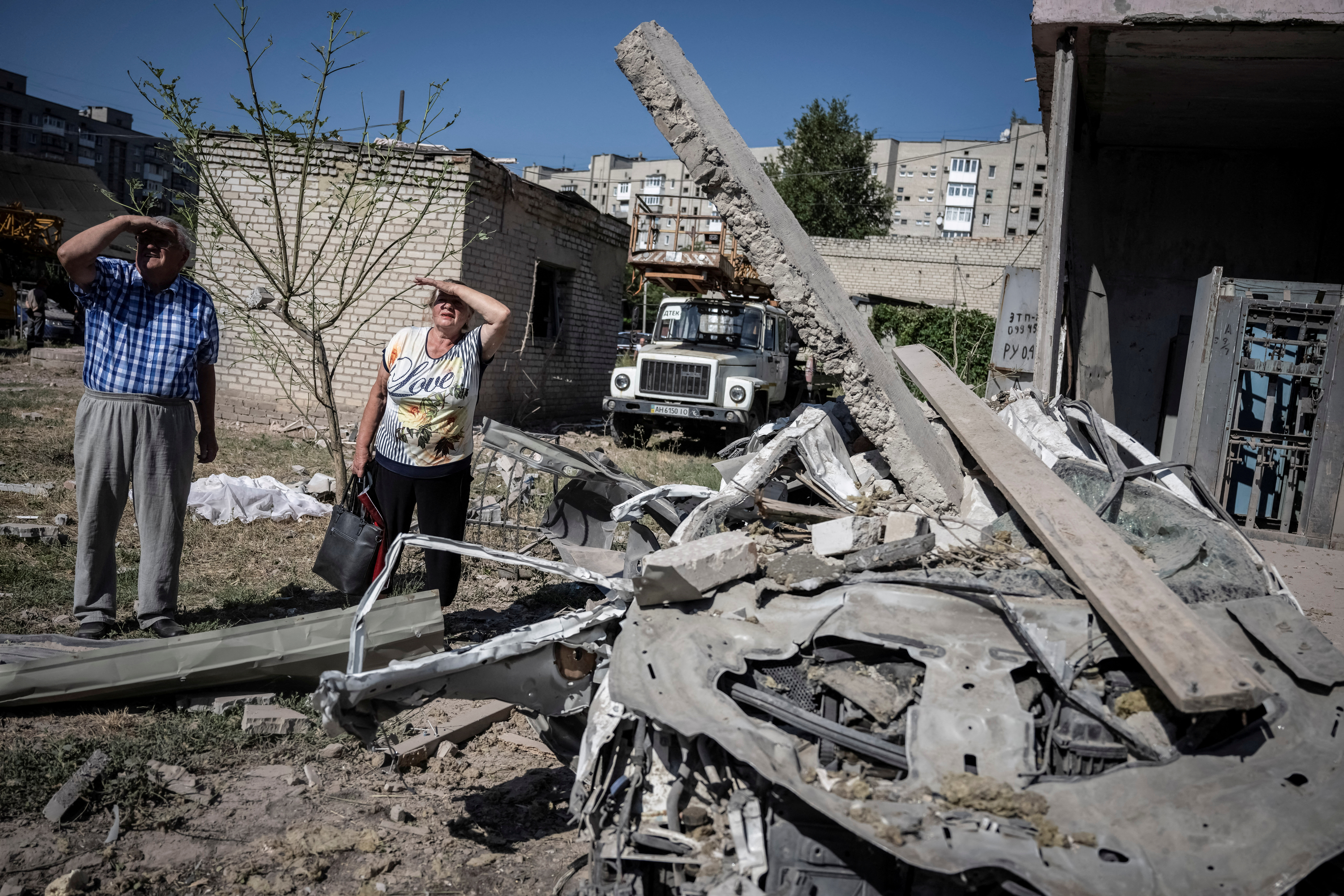 Local residents stand outside an apartment building damaged by a Russian missile strike, amid Russia's attack on Ukraine, in Pokrovsk, Donetsk region, Ukraine August 8, 2023. REUTERS