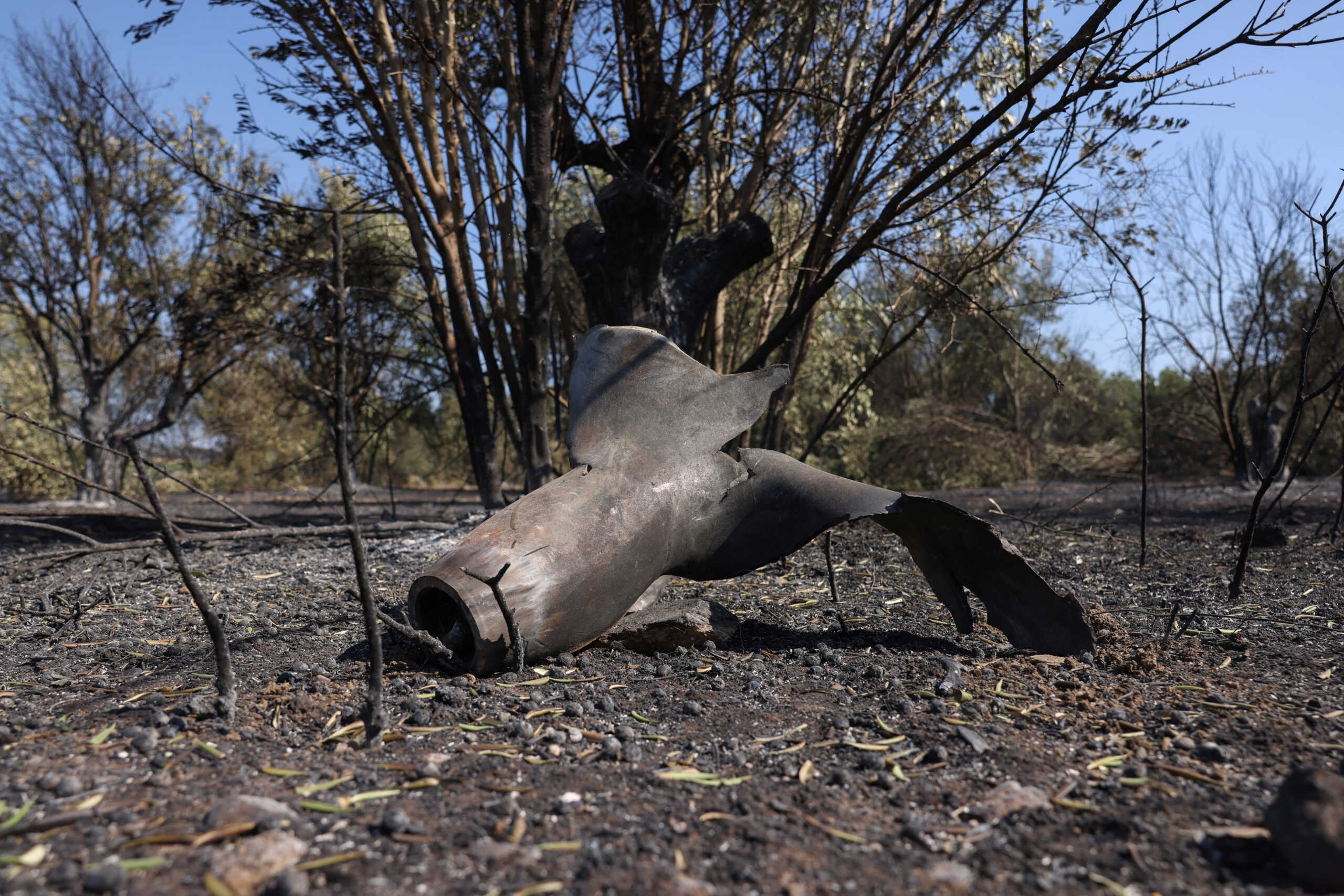 A piece of metal sits on a farmer's field, following the explosion of a Hellenic Air Force ammunition depot, during a wildfire, in Nea Aghialos, Greece, July 28, 2023. REUTERS