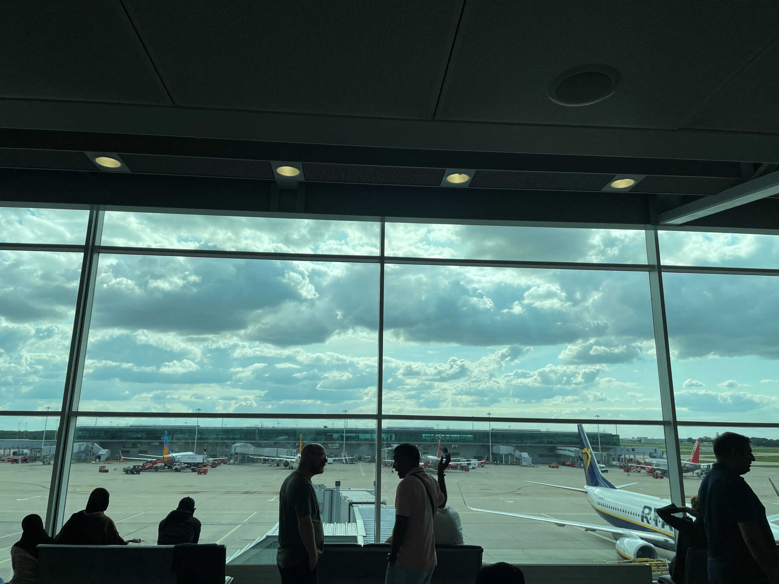 Passengers awaiting news on cancelled or delayed flights at London's Stansted Airport gesture as they discuss the situation on Monday, in London, Britain August 28, 2023. REUTERS