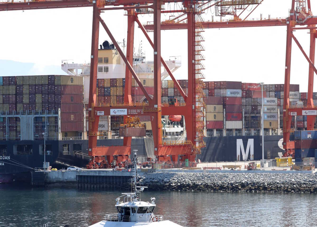 A commuter SeaBus passes a berthed container ship after Pacific coast dock workers with the International Longshore and Warehouse Union (ILWU) returned to clear the backlog of containers and bulk cargo from a 13-day strike in Vancouver, British Columbia, Canada, July 20, 2023. REUTERS