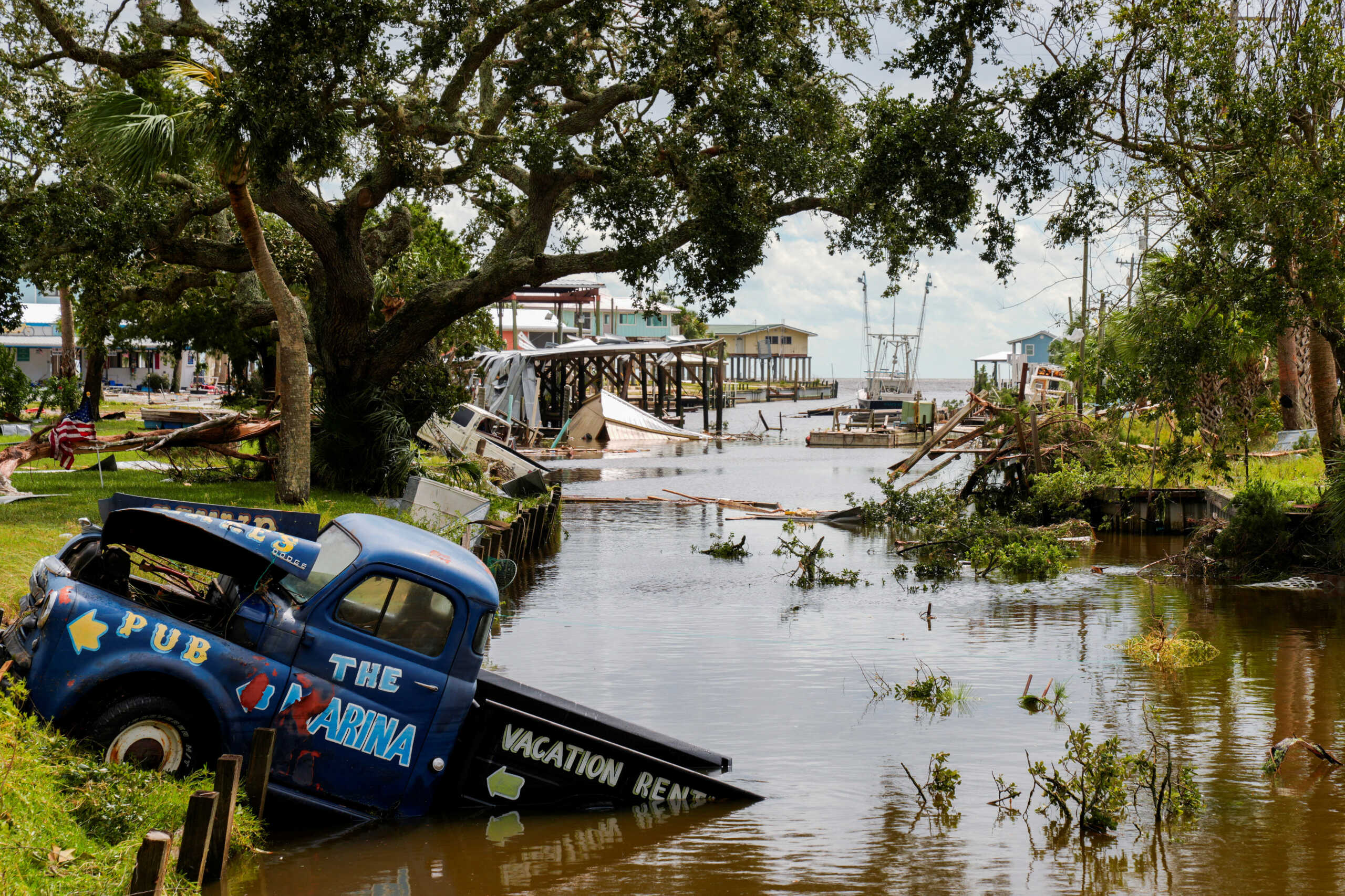 A view of a vehicle partially submerged in a canal after the arrival of Hurricane Idalia in Horseshoe Beach, Florida, U.S., August 30, 2023. REUTERS
