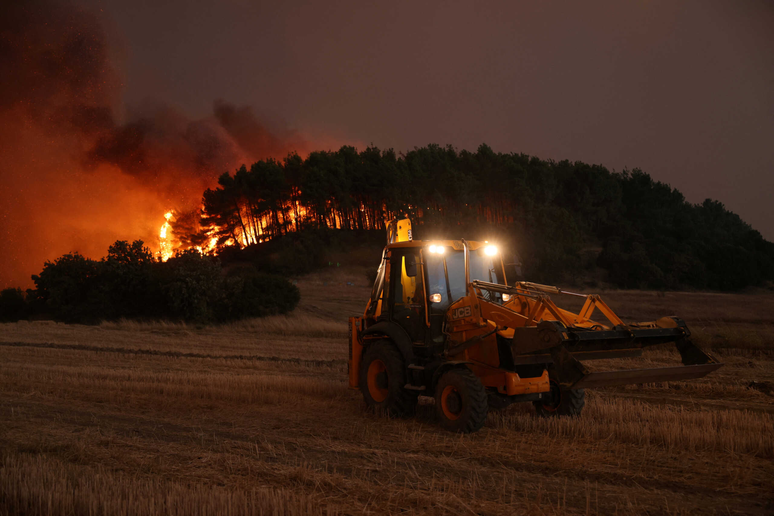 A bulldozer operates as a wildfire burns near the village of Avantas in the region of Evros, Greece, August 21, 2023. REUTERS