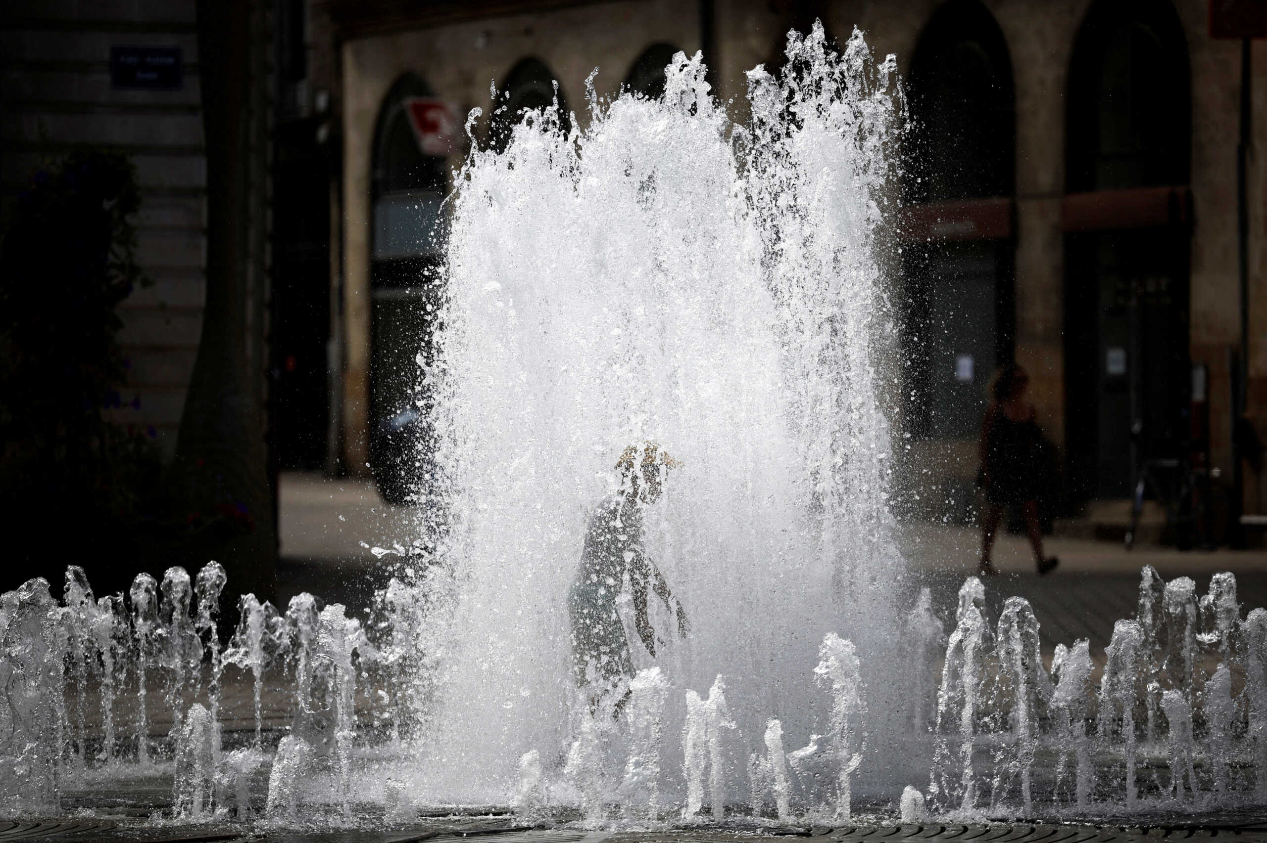 A child cools off in a public fountain during high temperatures in Nantes, France, August 23, 2023. REUTERS