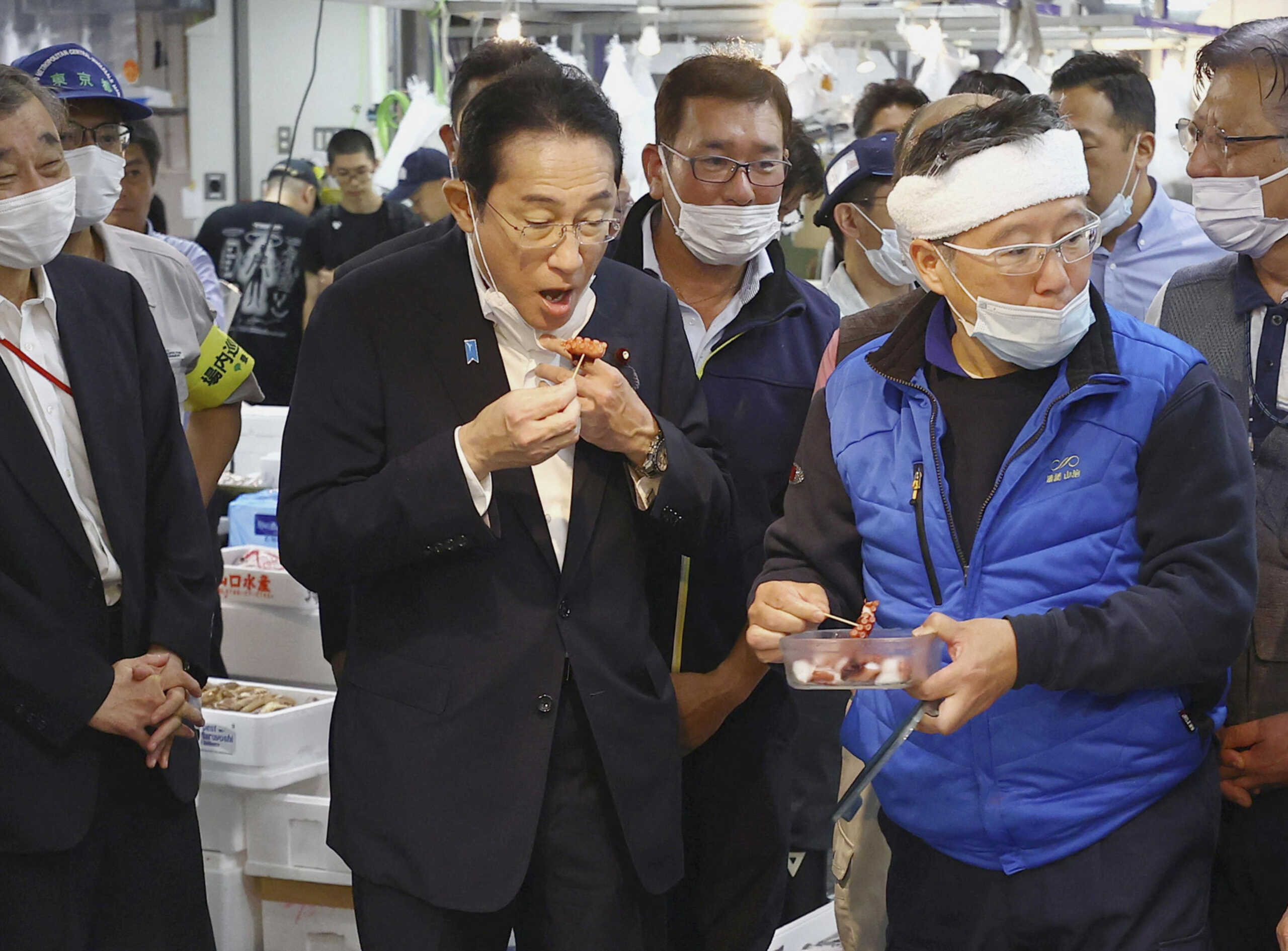 Japan's Prime Minister Fumio Kishida tastes seafood from Fukushima region during his visit to Toyosu fish market in Tokyo August 31, 2023, in this photo released by Kyodo.  Mandatory credit Kyodo
