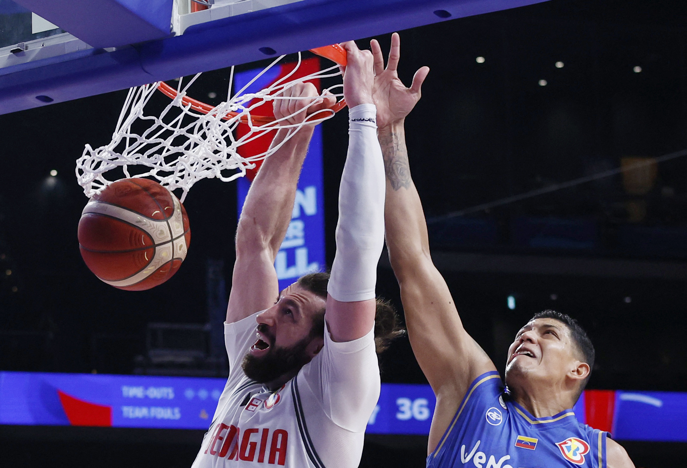 Basketball - FIBA World Cup 2023 - First Round - Group F - Georgia v Venezuela - Okinawa Arena, Okinawa, Japan - August 30, 2023 Georgia's Tornike Shengelia scores a basket as Venezuela's Jhornan Zamora looks on REUTERS