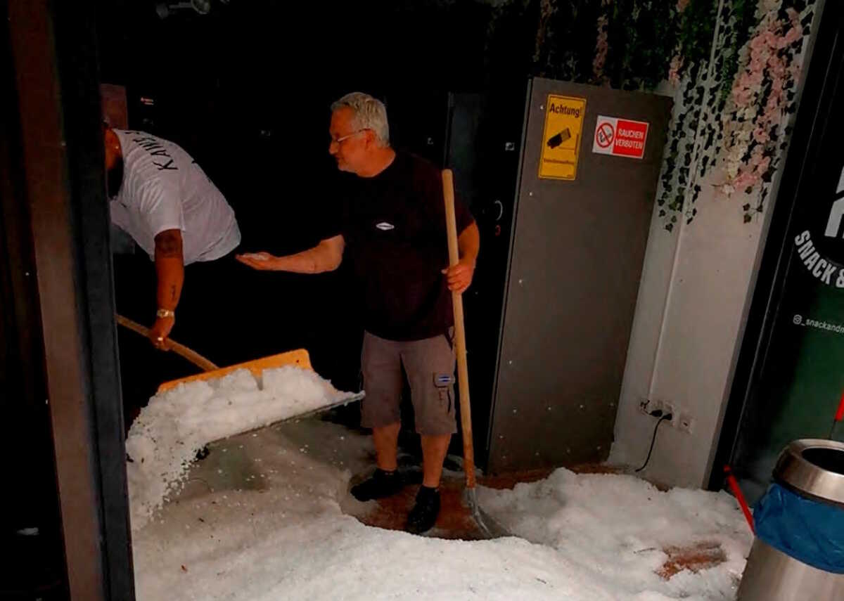People clear out hail from the inside of a building, in the aftermath of a hailstorm in Reutlingen, Germany August 4, 2023 in this screengrab obtained from a social media video. Timo Mendritzki