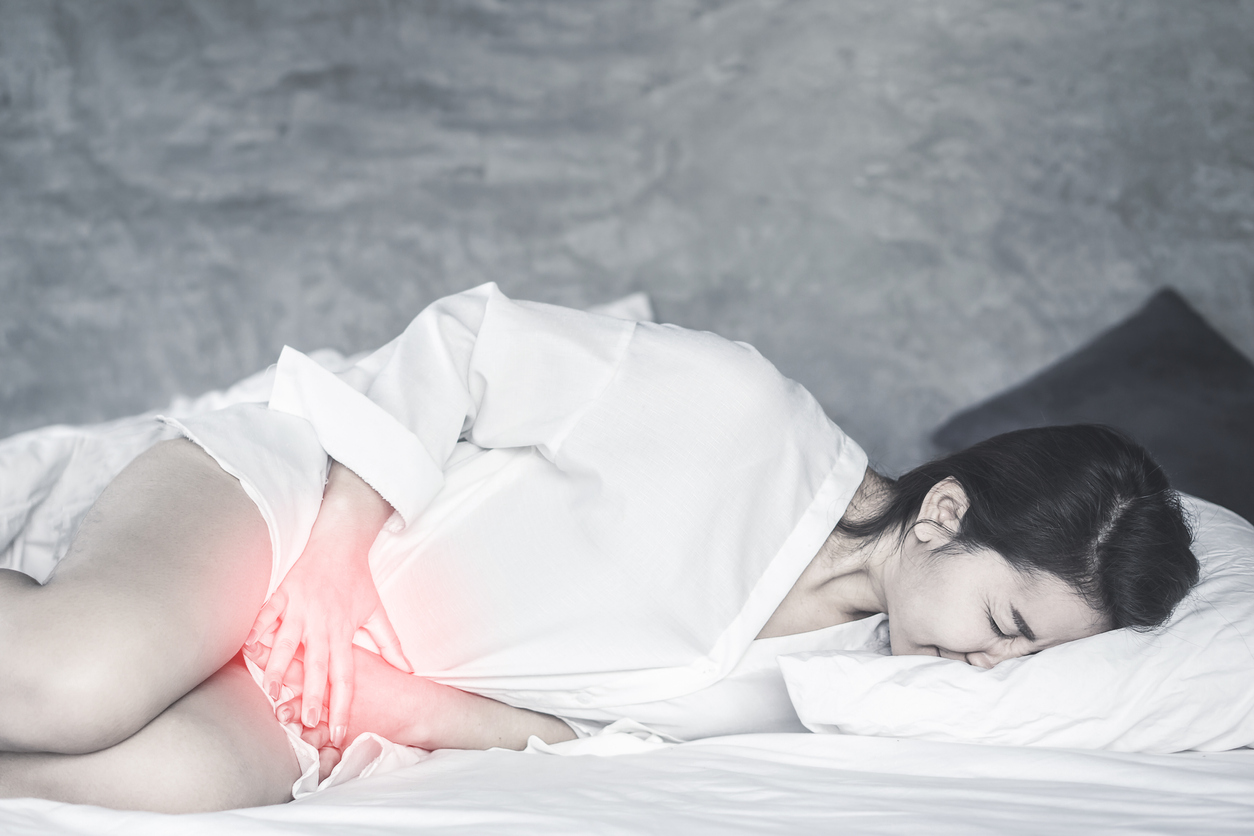 Asian woman laying down on bed hand holding her crotch suffering from pain,itchy concept background