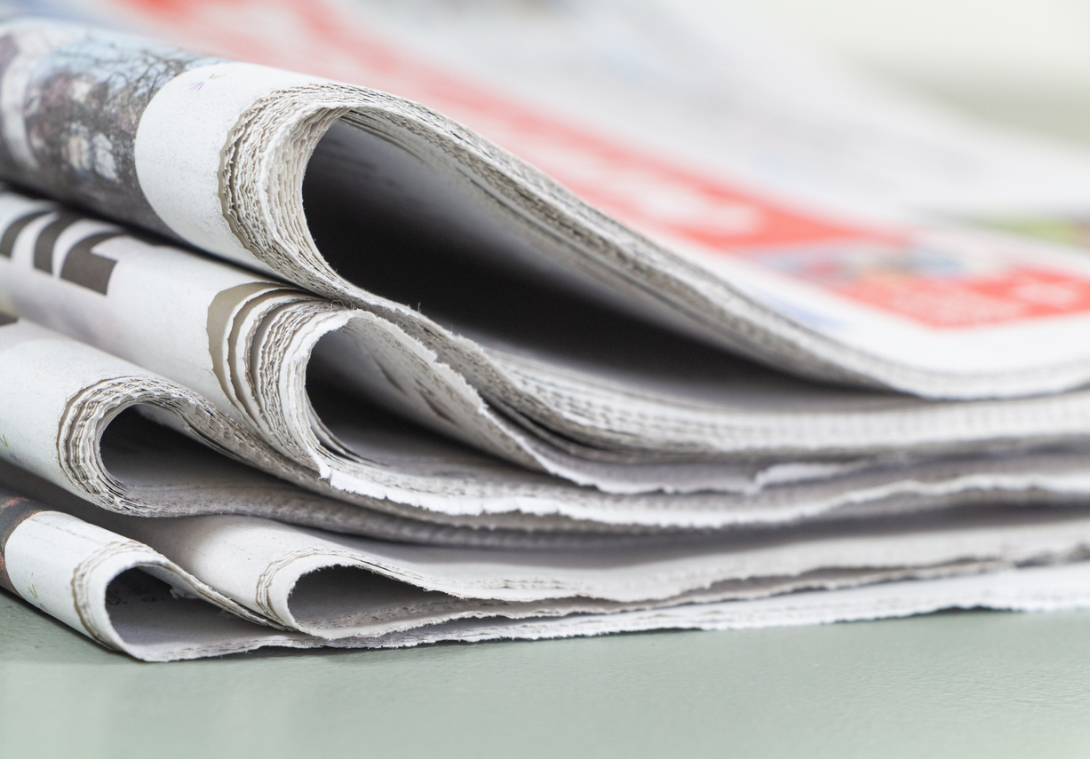 Pile of folded french newspapers on a table