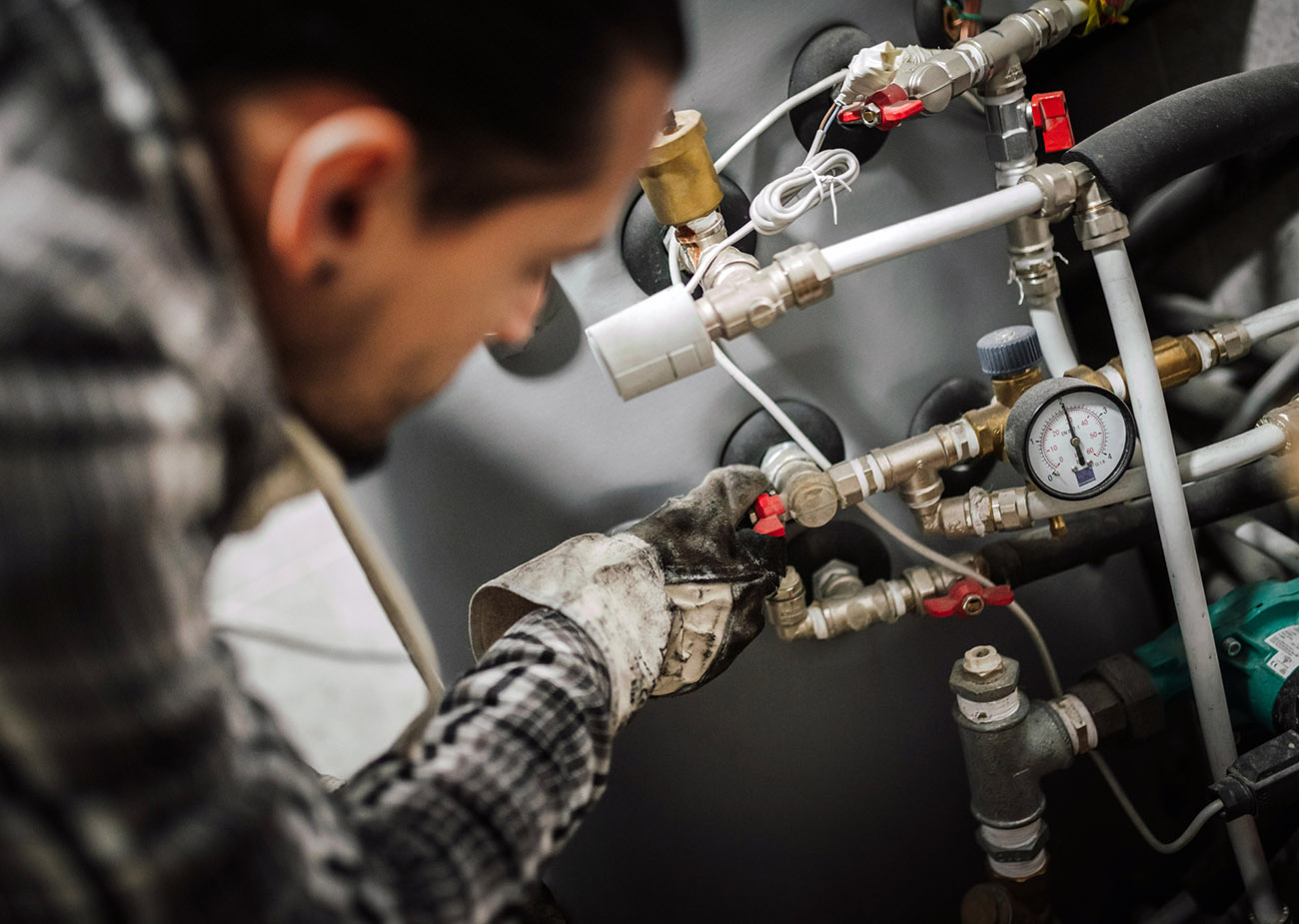 Close up photo of a man fixing the pipes at home.