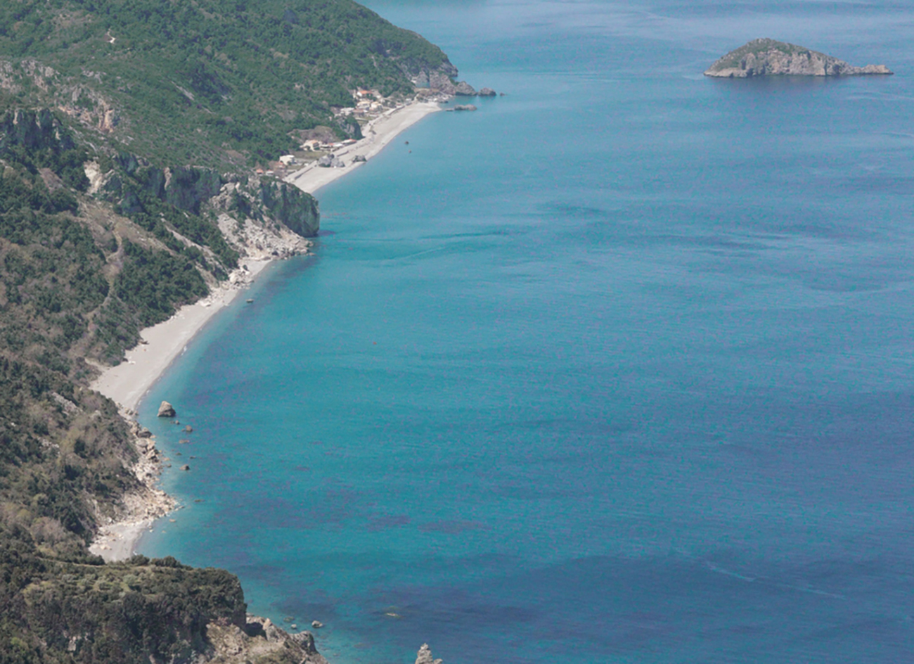 A view into paradise-looking Paralia Chiliadou beach with its mountainous shore, in Greece