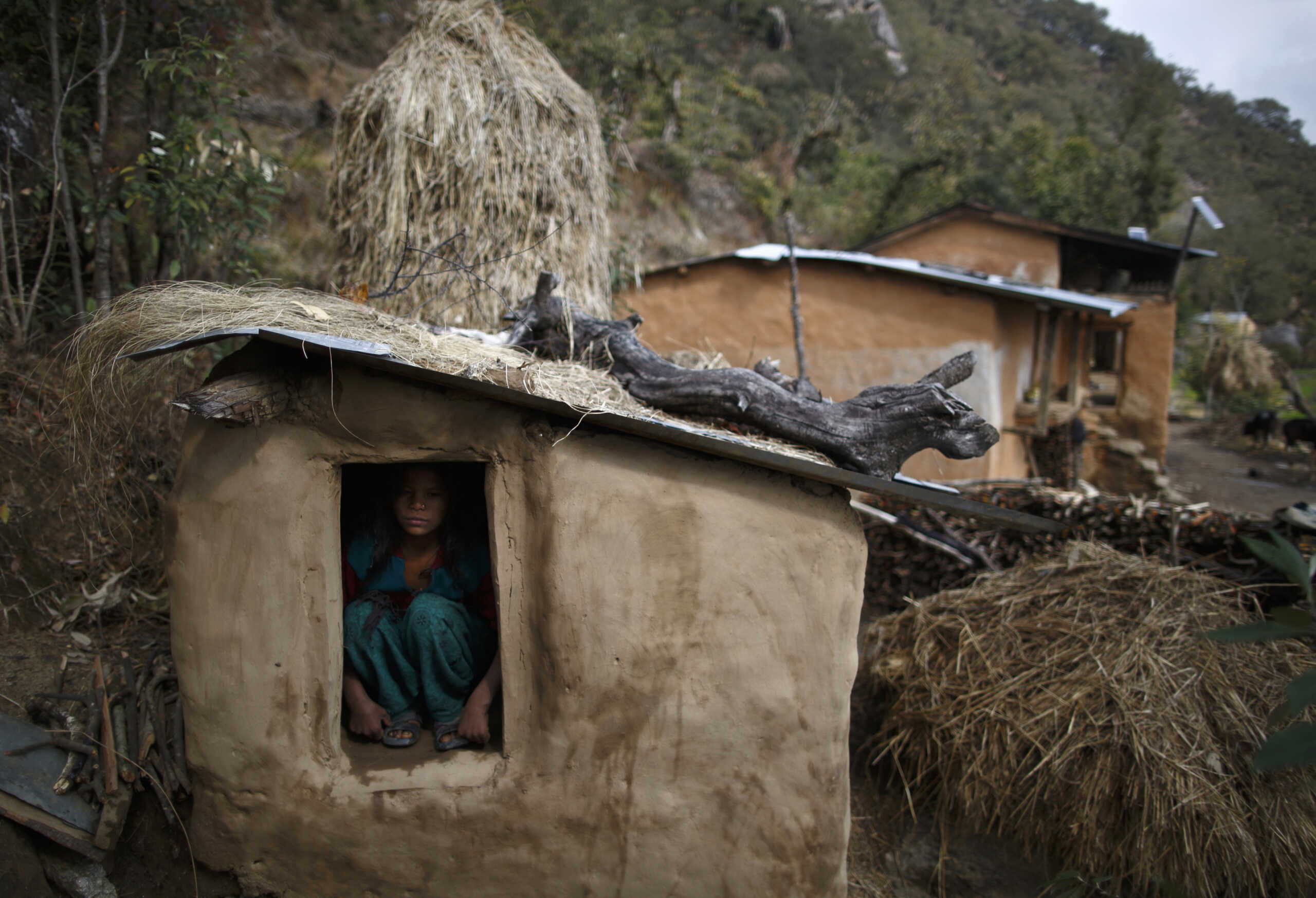 Uttara Saud, 14, sits inside a Chaupadi shed in the hills of Legudsen village in Achham District in western Nepal February 16, 2014. Chaupadi is a tradition observed in parts of Nepal, which cuts women off from the rest of society when they are menstruating. Women who practice traditional chaupadi have to sleep in sheds or outbuildings while they are on their period, often with little protection from the elements. They are not allowed to enter houses or temples, use normal public water sources, take part in festivals or touch others during their menstruation, according to a United Nations field bulletin on the issue. Isolated in sheds that are frequently rickety and unhygienic, there have been cases of women dying while practicing chaupadi from illness, exposure, animal attacks or from fires lit in poorly ventilated spaces. Chaupadi was banned by Nepal's Supreme Court in 2005, but it is still common in the country's far and mid-western regions. Picture taken February 16, 2014. REUTERS

ATTENTION EDITORS: PICTURE 09 OF 20 FOR PACKAGE 'BANISHED ONCE A MONTH' 
TO FIND ALL IMAGES SEARCH 'CHAUPADI'