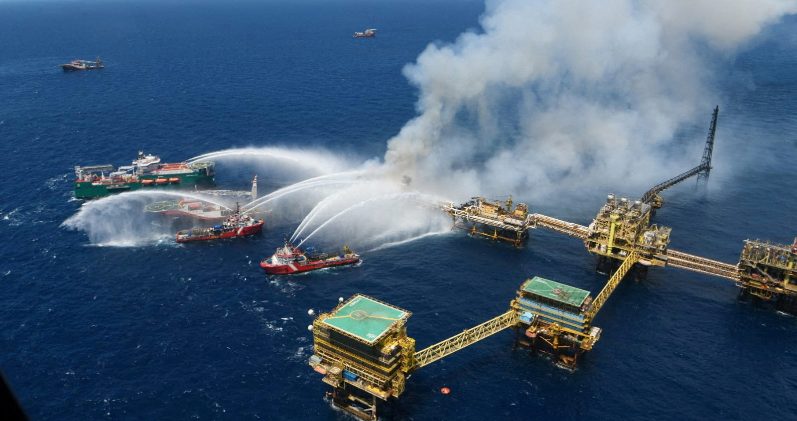 Boats spray water onto an offshore oil platform that caught fire at the Pemex's Cantarell Field, in the Bay of Campeche, Gulf of Mexico, Mexico July 7, 2023. Courtesy Petroleos Mexicanos (PEMEX) @Pemex