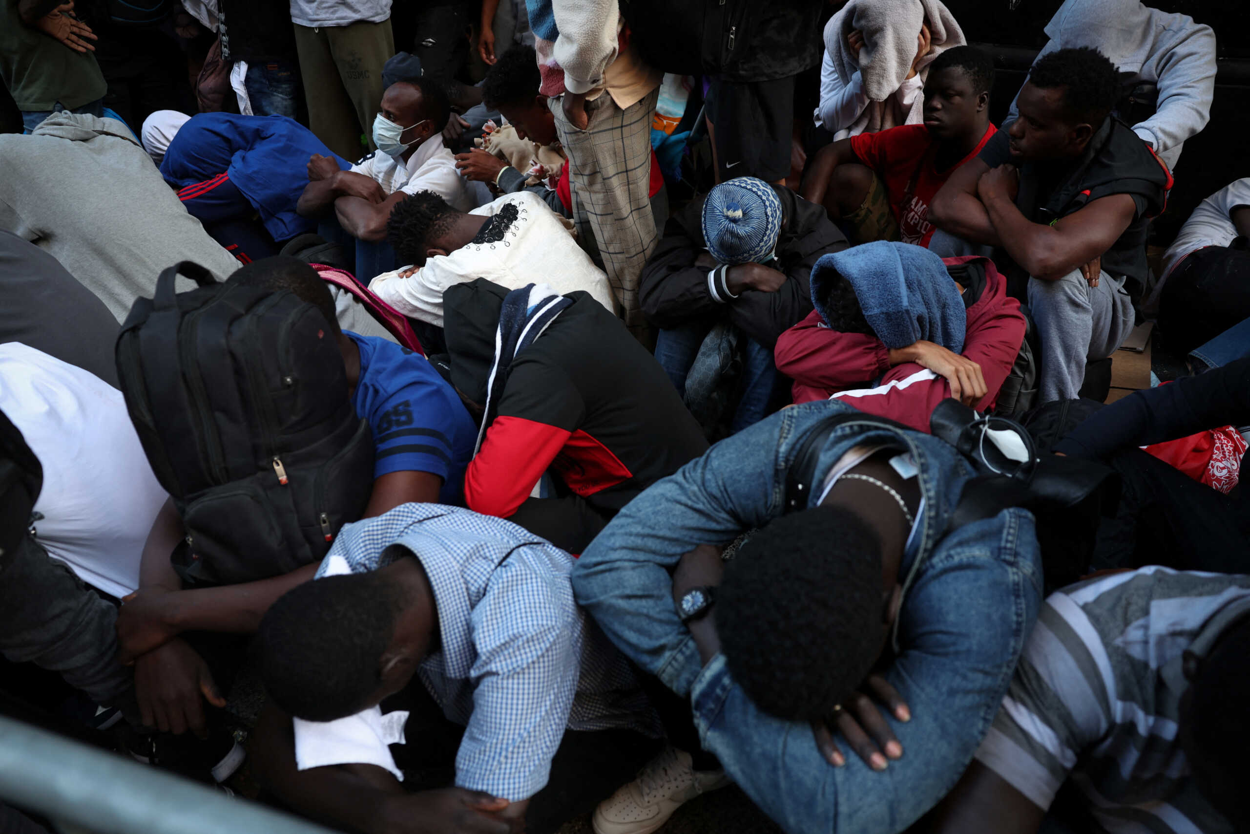 Recently arrived migrants to New York City wait on the sidewalk outside of the Roosevelt Hotel in midtown, Manhattan, where a temporary reception center has been established in New York City, New York, U.S., August 1, 2023. REUTERS