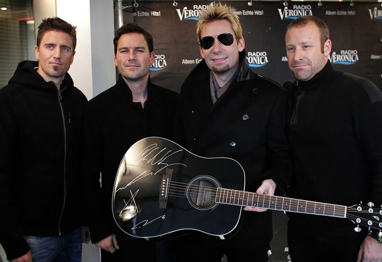 epa03955545 (L-R) Daniel Adair, Ryan Peake, Chad Kroeger and Mike Kroeger of Canadian rock band Nickelback pose with a signed guitar in Naarden, The Netherlands, 18 November 2013. The proceeds from the auction of the instrument will be donated to the victims of Typhoon Haiyan in the Philippines. The Dutch public and commercial radio and TV stations are raising money for the victims of the typhoon. Giro 555, an account of the cooperating aid organizations, has been opened on 11 November and has raised more than 10,000,000 euro so far, reports state.  EPA