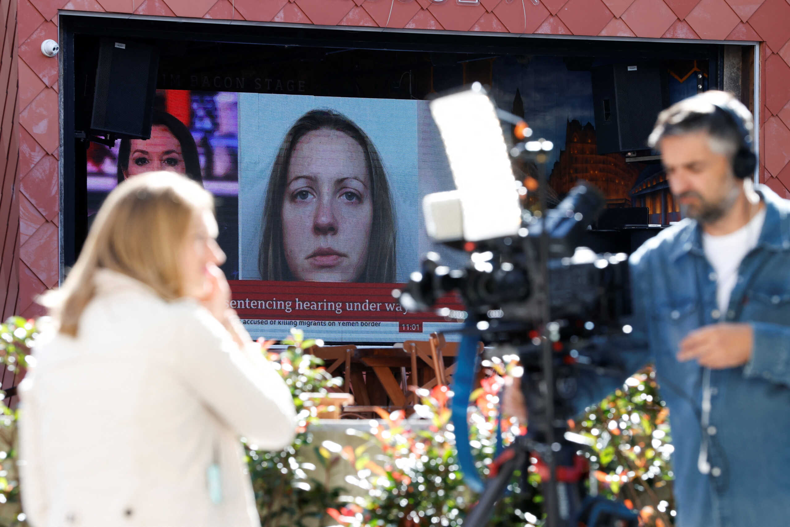 Members of the media work near a large screen showing a picture of convicted hospital nurse Lucy Letby, ahead of her sentencing, outside the Manchester Crown Court, in Manchester, Britain, August 21, 2023. REUTERS